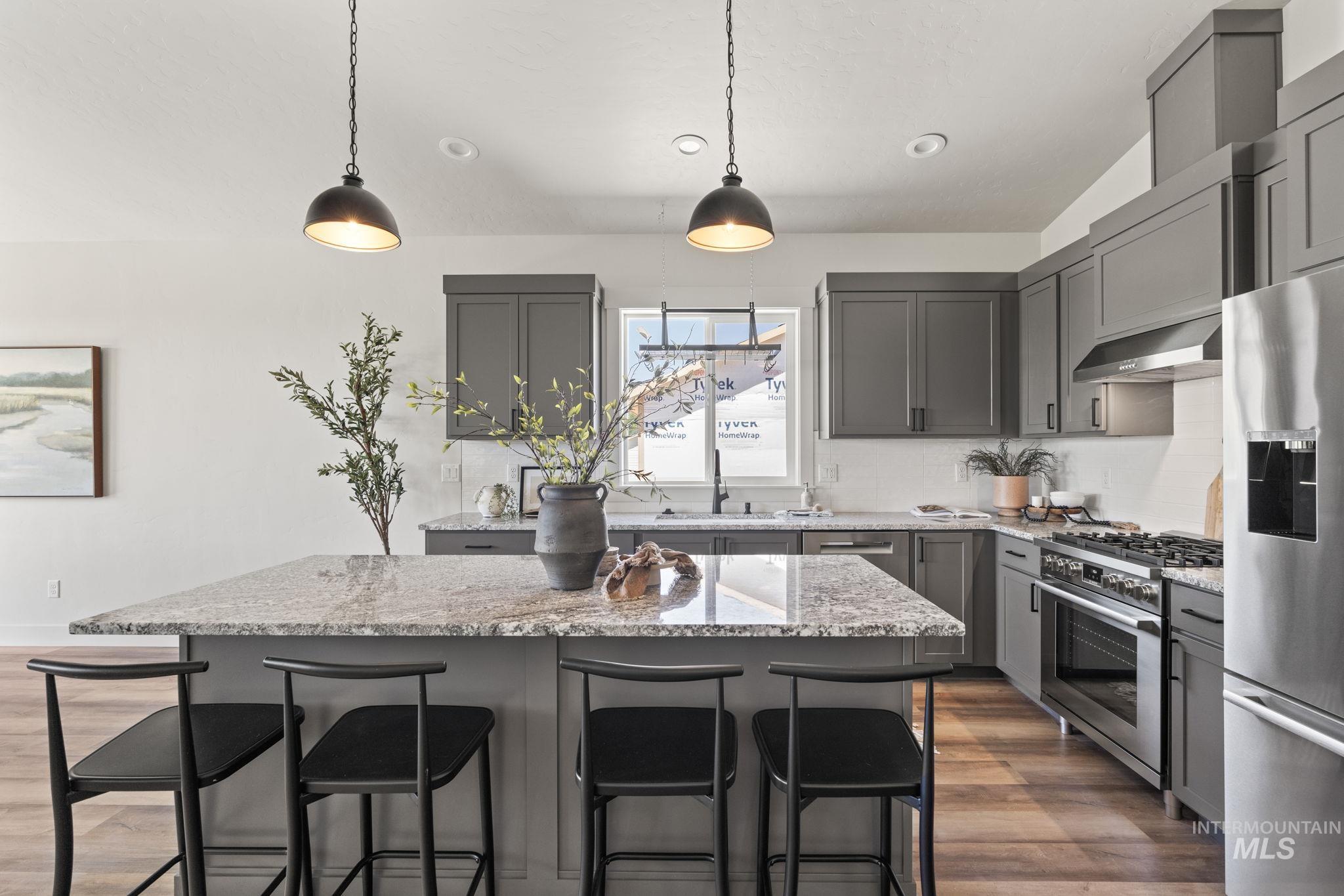 Kitchen with gray cabinets, dark wood-type flooring, stainless steel appliances, light stone countertops, and recessed lighting