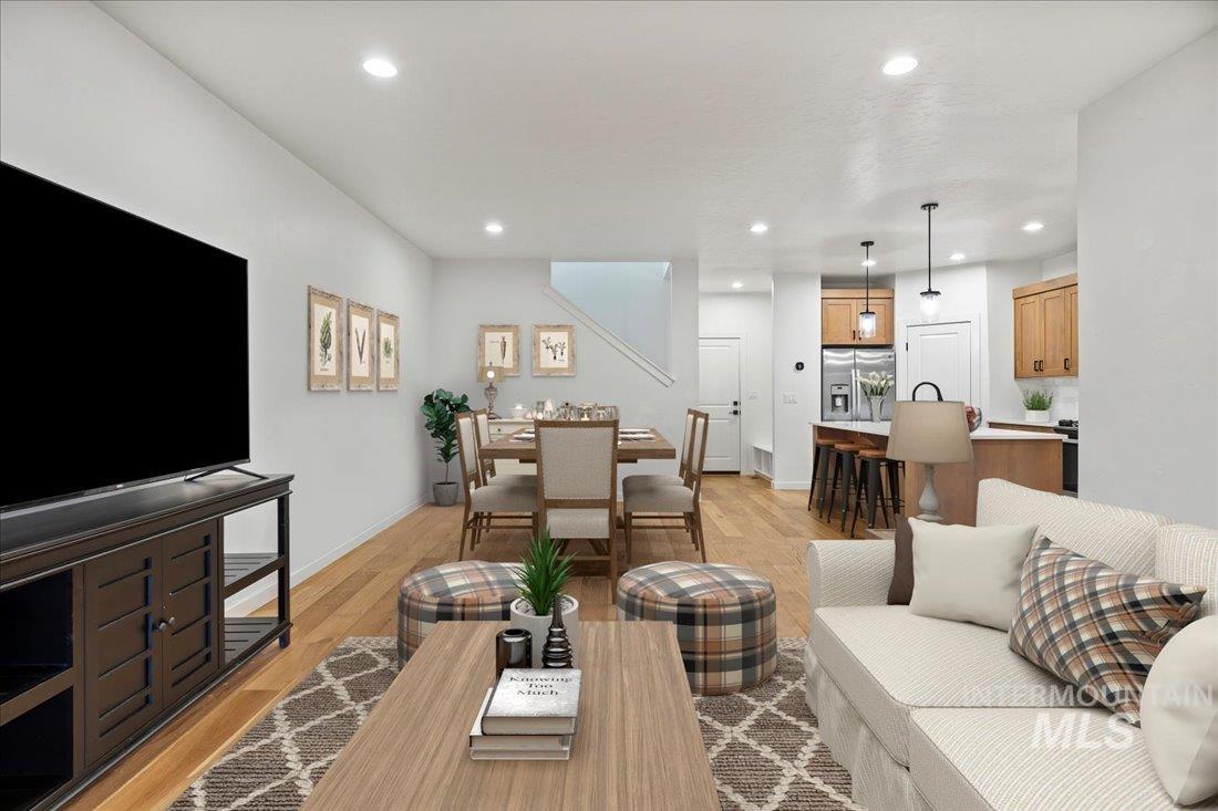 Living area with light wood finished floors and recessed lighting