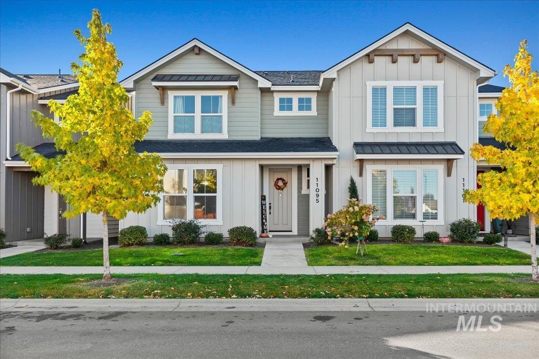 View of front of property with board and batten siding and a front lawn