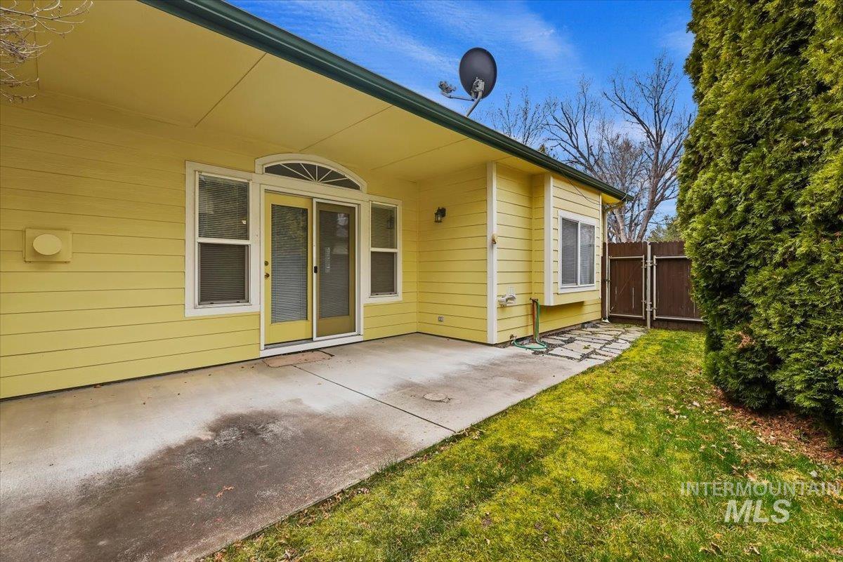 Doorway to property featuring a patio and a gate