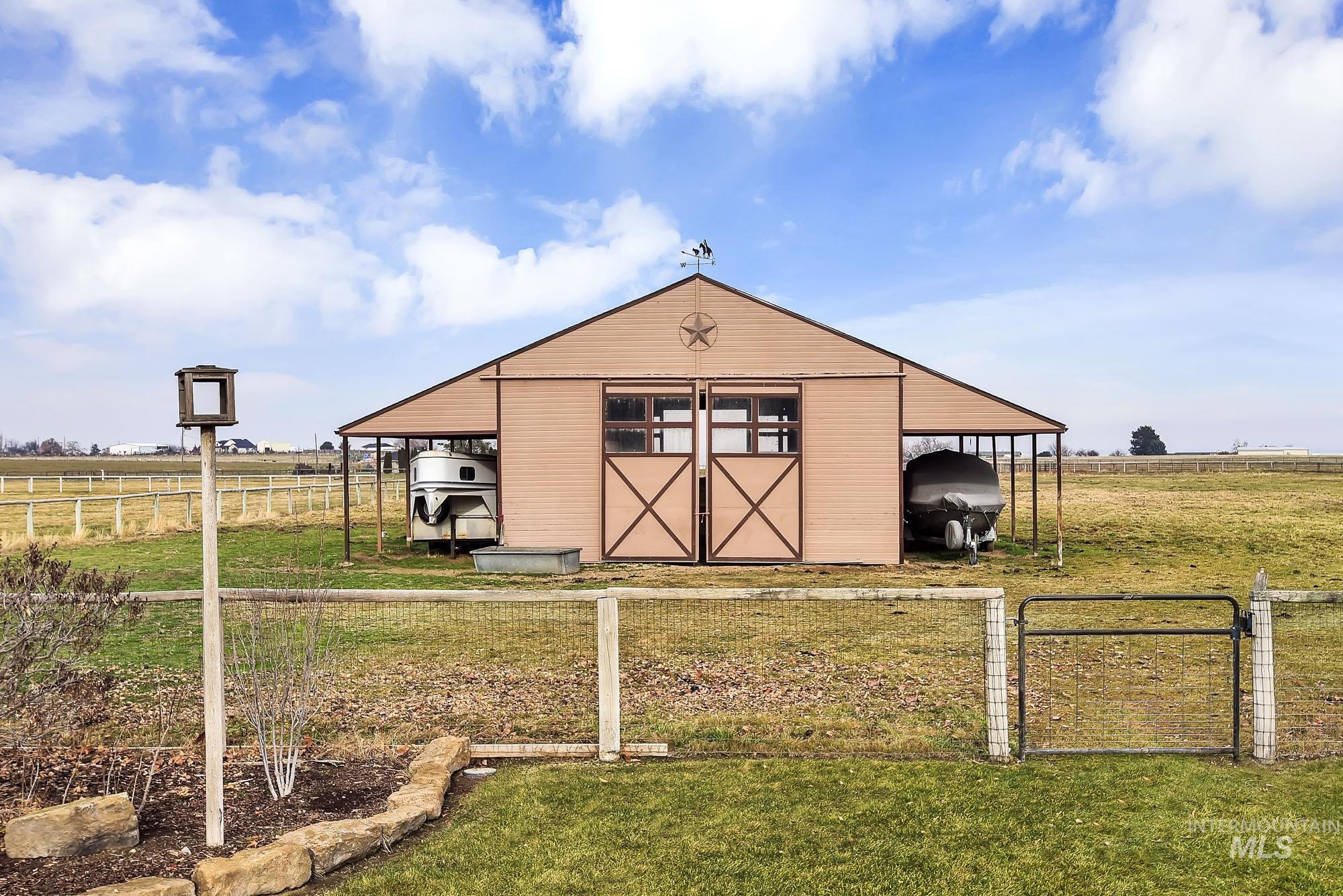 View of pole barn with side coverings for RVs or farm equipment - a view of countryside and distant mountains