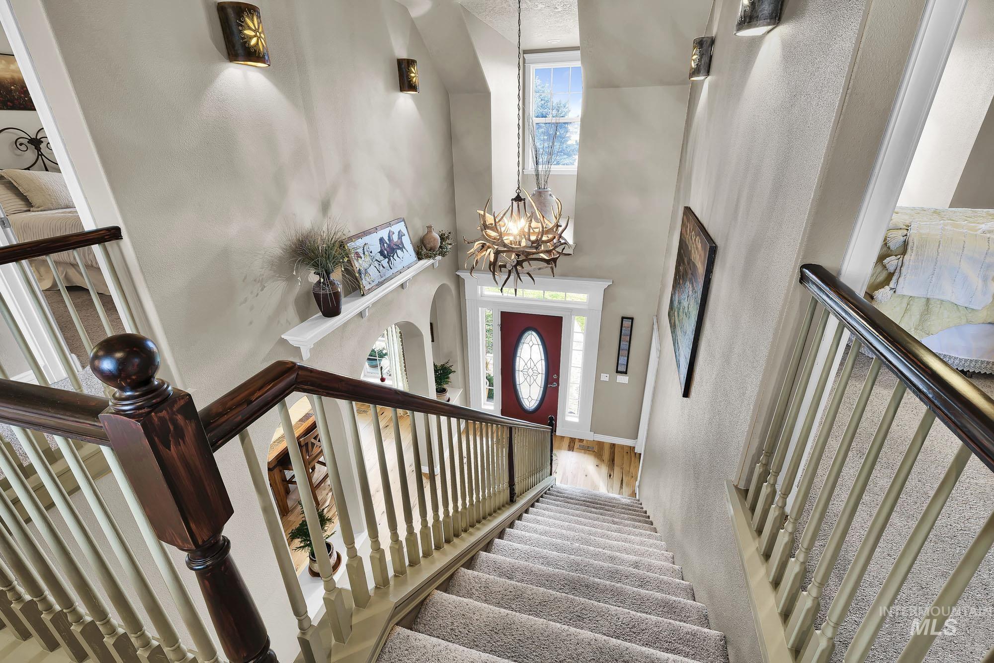 Foyer featuring hanging lights, a high ceiling, wood finished floors, and arched walkways