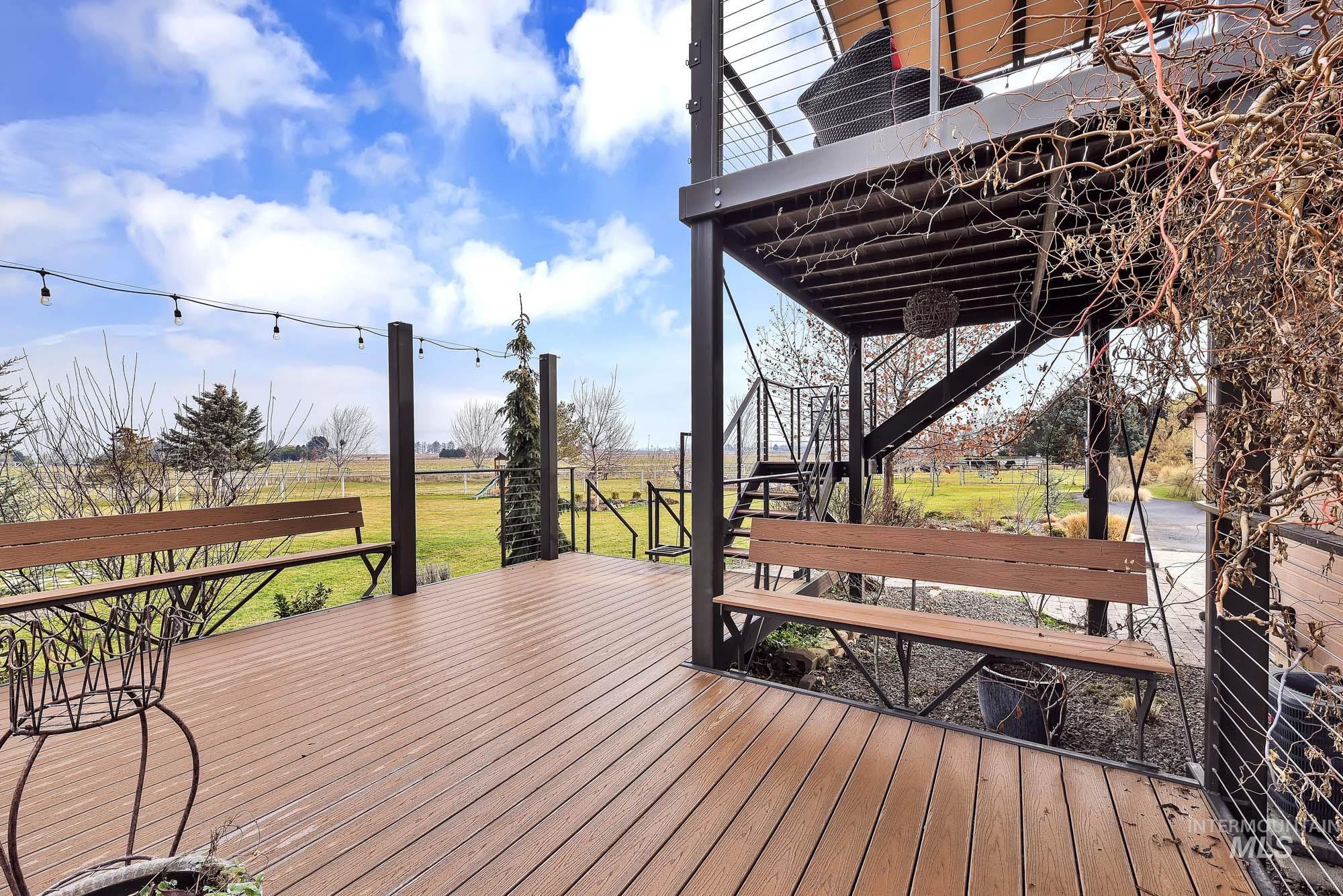 Wooden deck with stairway to upper deck area and a view of rural / pastoral area