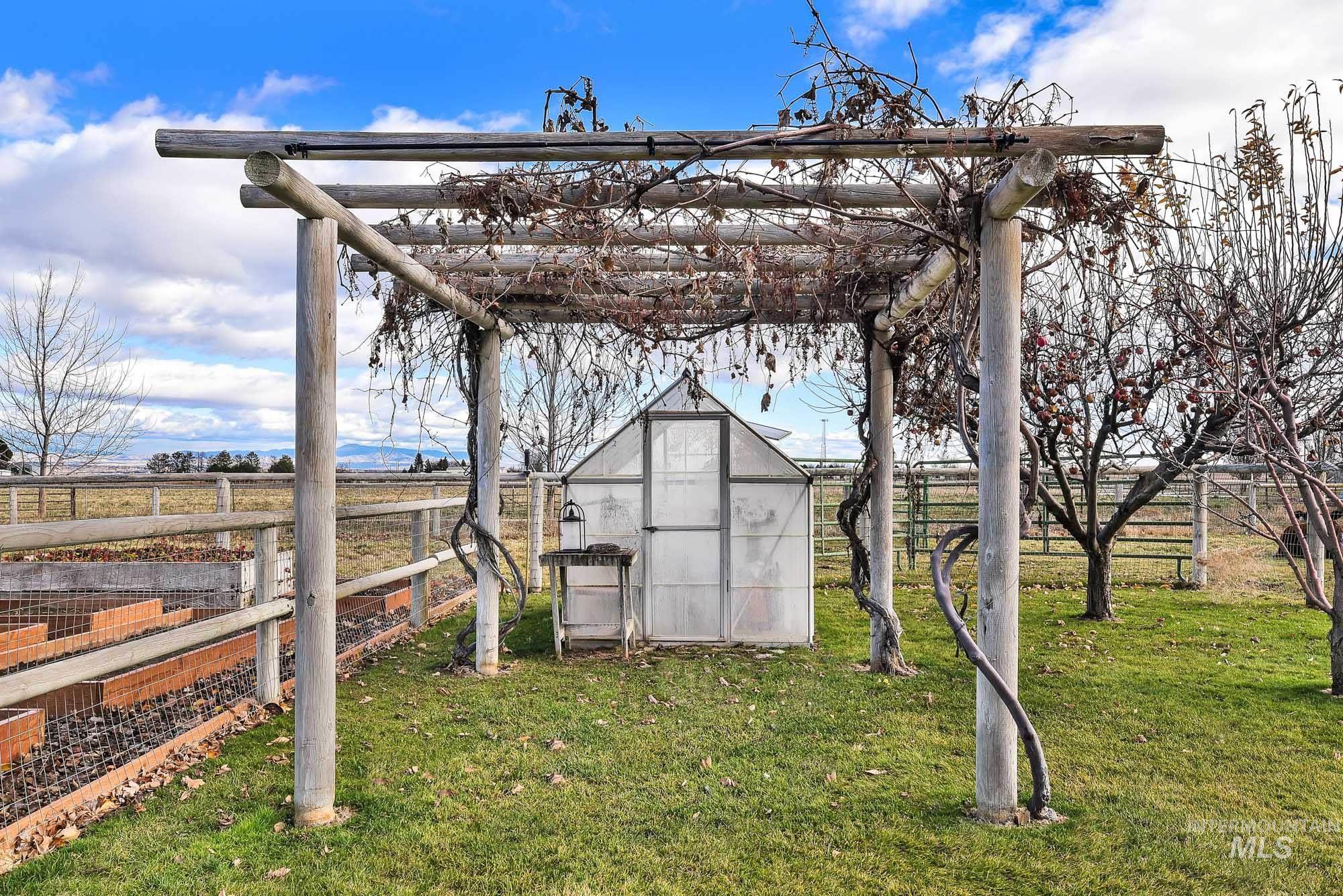 View of grape arbor featuring an exterior greenhouse