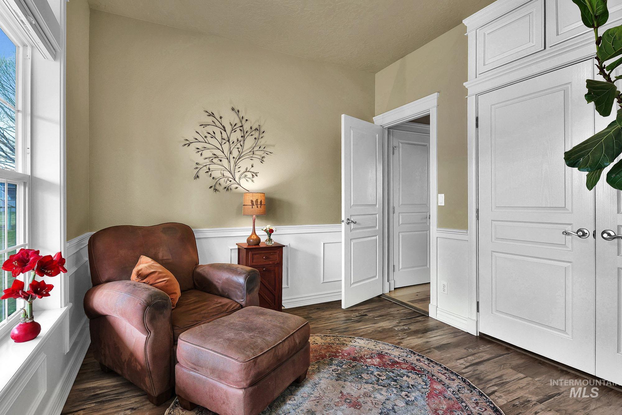 Sitting room with dark wood-style floors and wainscoting