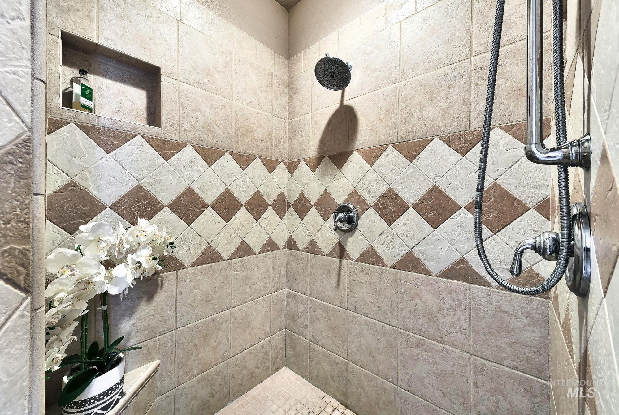 Walk in shower featuring fully tiled shower and dual heads