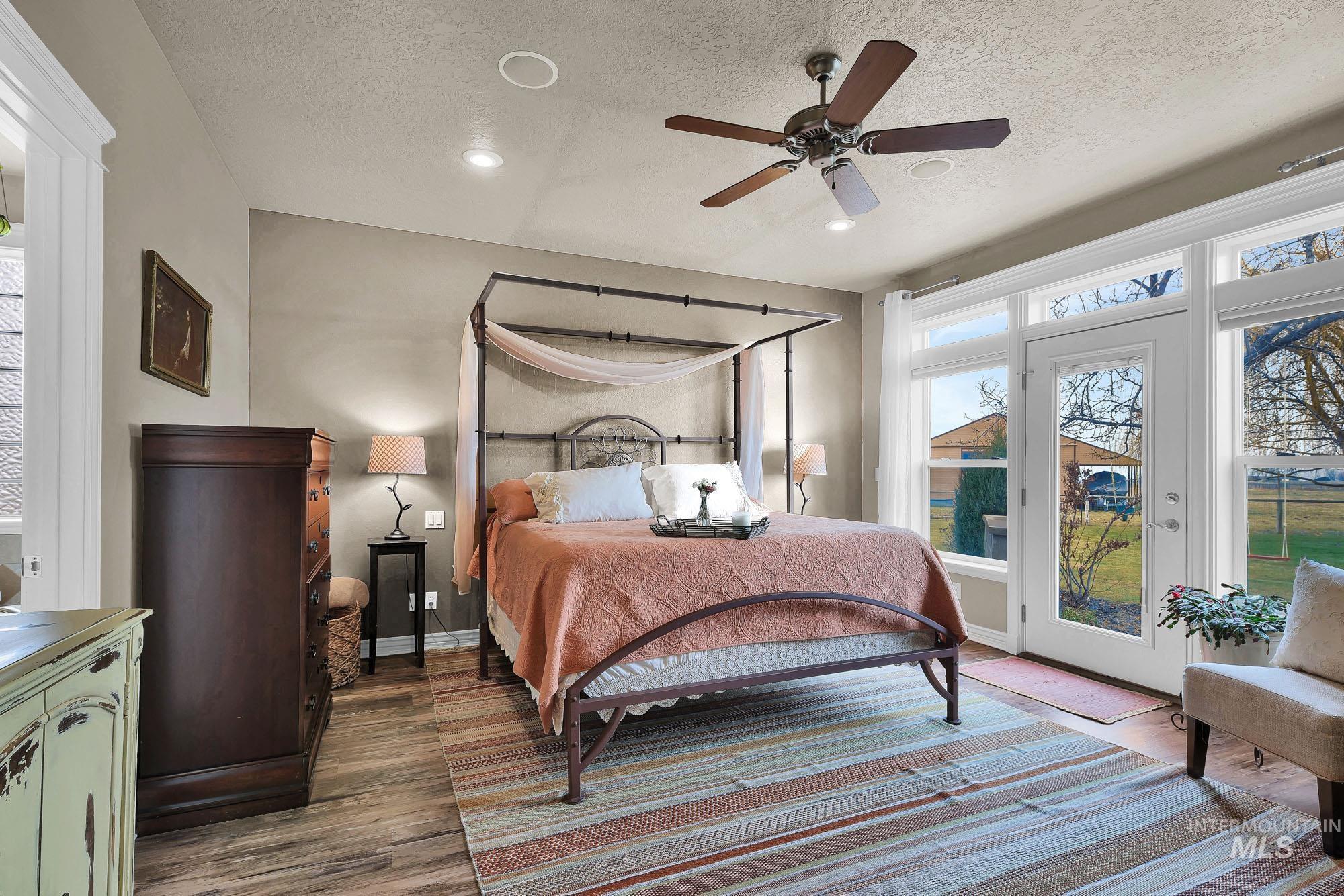 Bedroom featuring recessed lighting, access to exterior, ceiling fan, multiple windows, and a textured ceiling