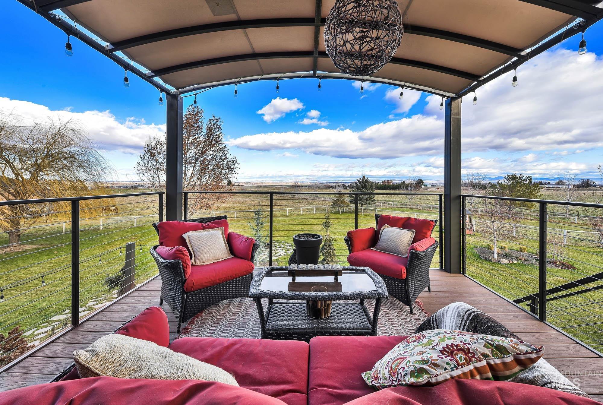 Upper terrace featuring an outdoor gathering space, a view of the expansive lawn, and a view of the mountains and area