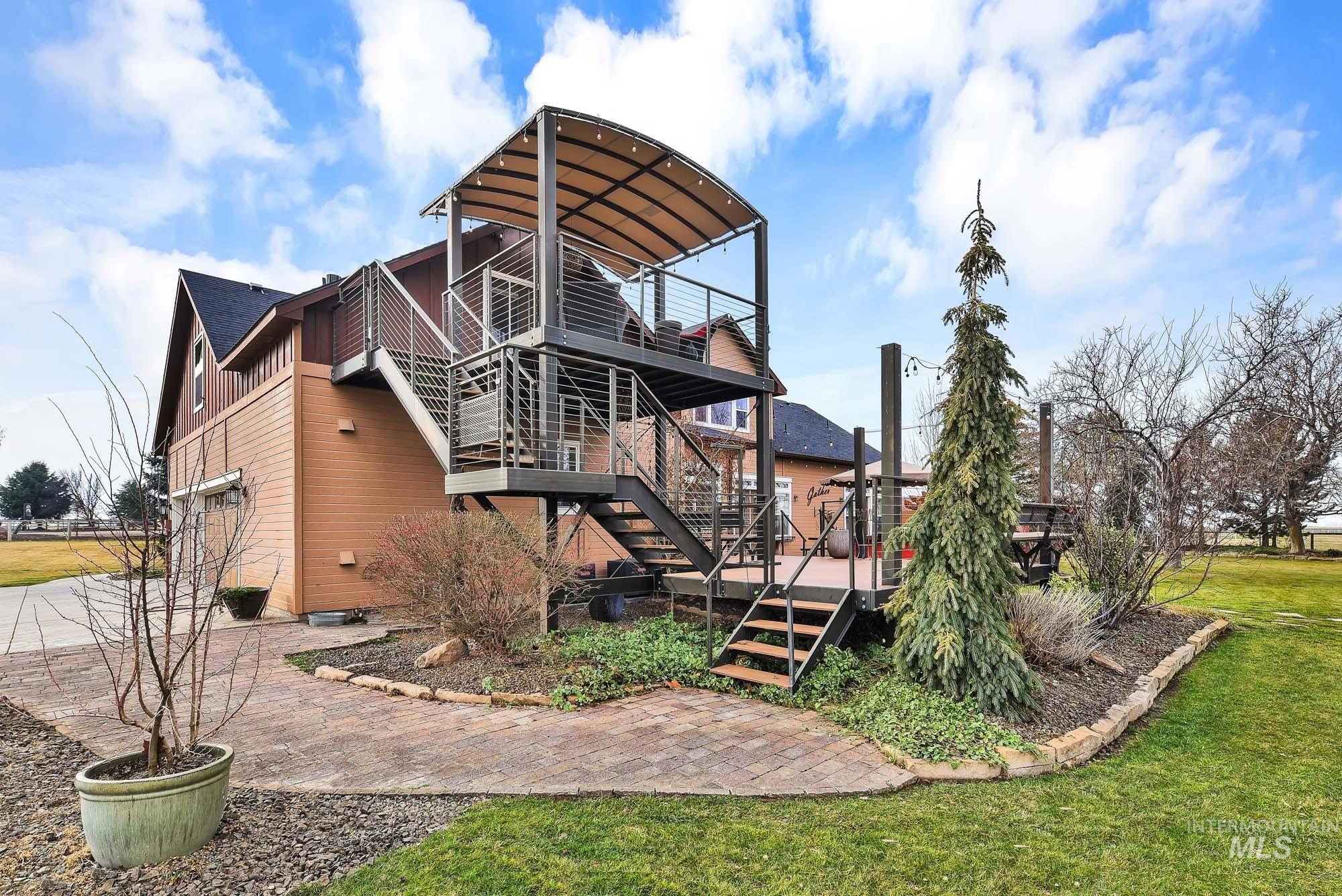 Rear view of property with stairs, a 2-story deck with railings, and an expansive yard