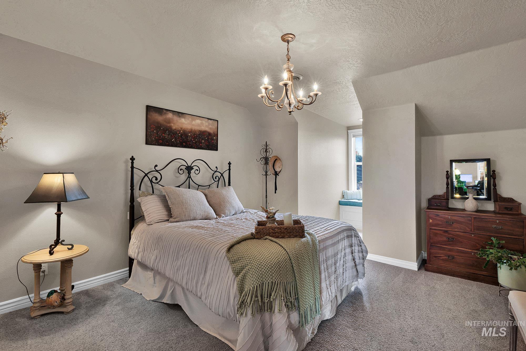 Bedroom featuring a unique window seat, a chandelier, and carpet flooring