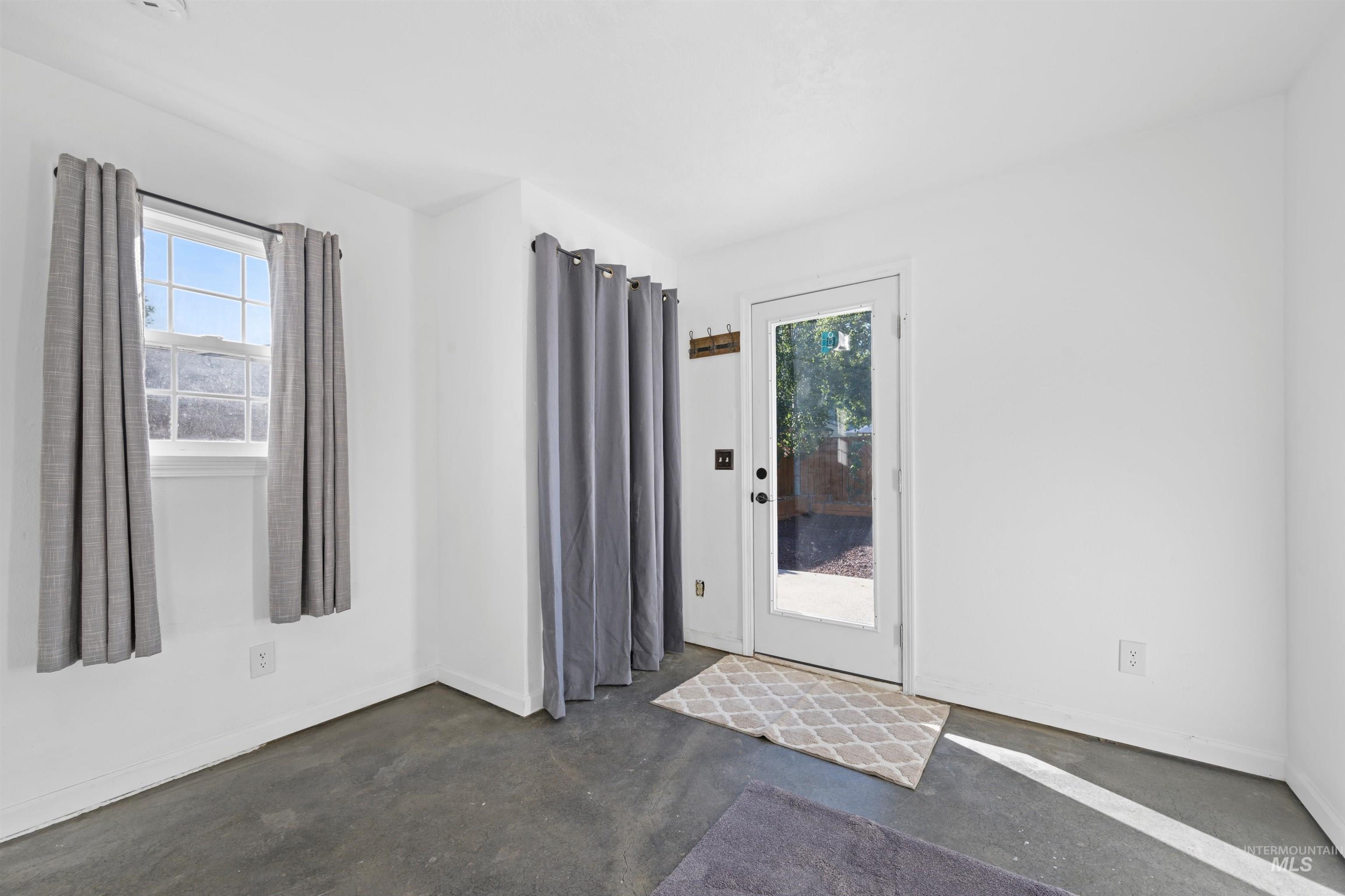 Doorway featuring plenty of natural light and concrete flooring