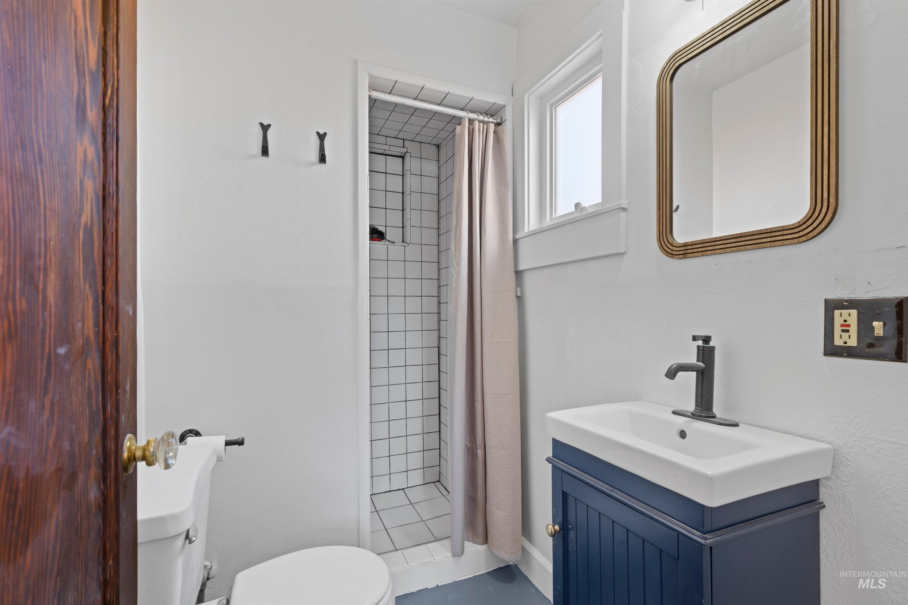 Full bath featuring a stall shower and vanity