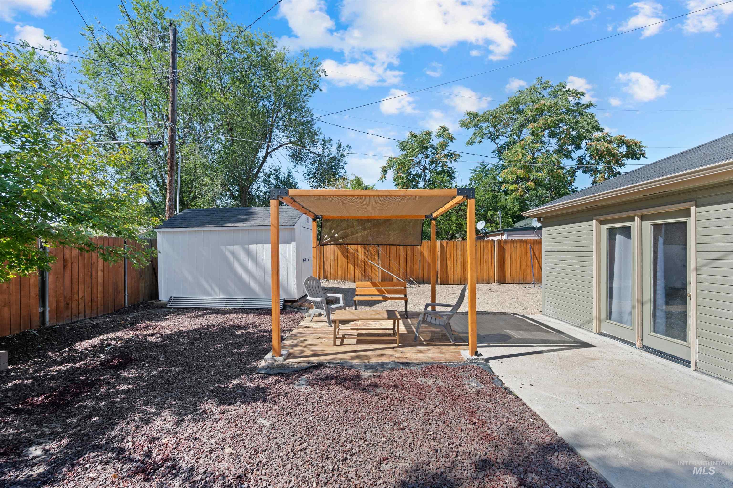 Fenced backyard with a patio area and a shed