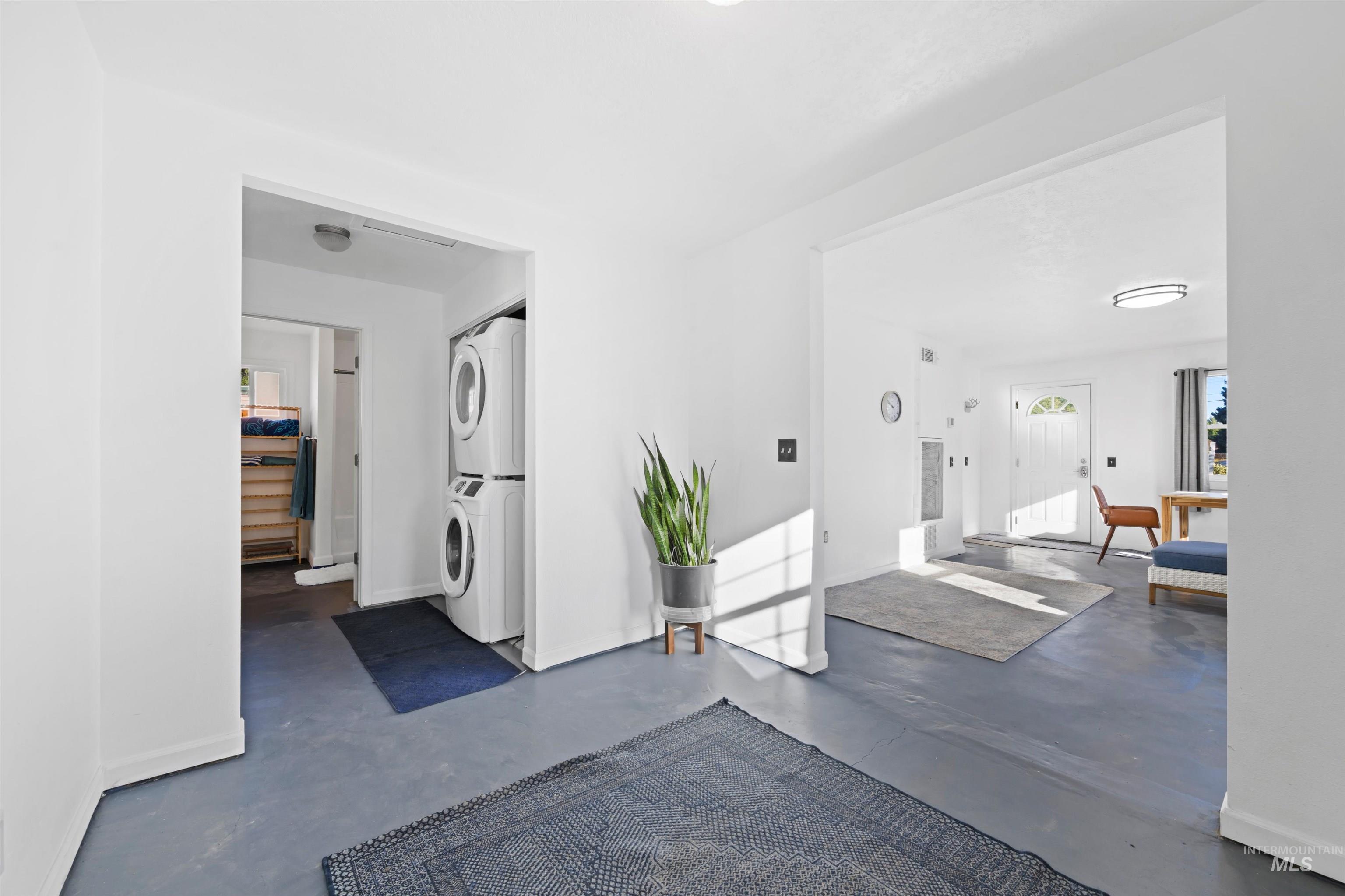 Foyer with stacked washer / drying machine and concrete floors