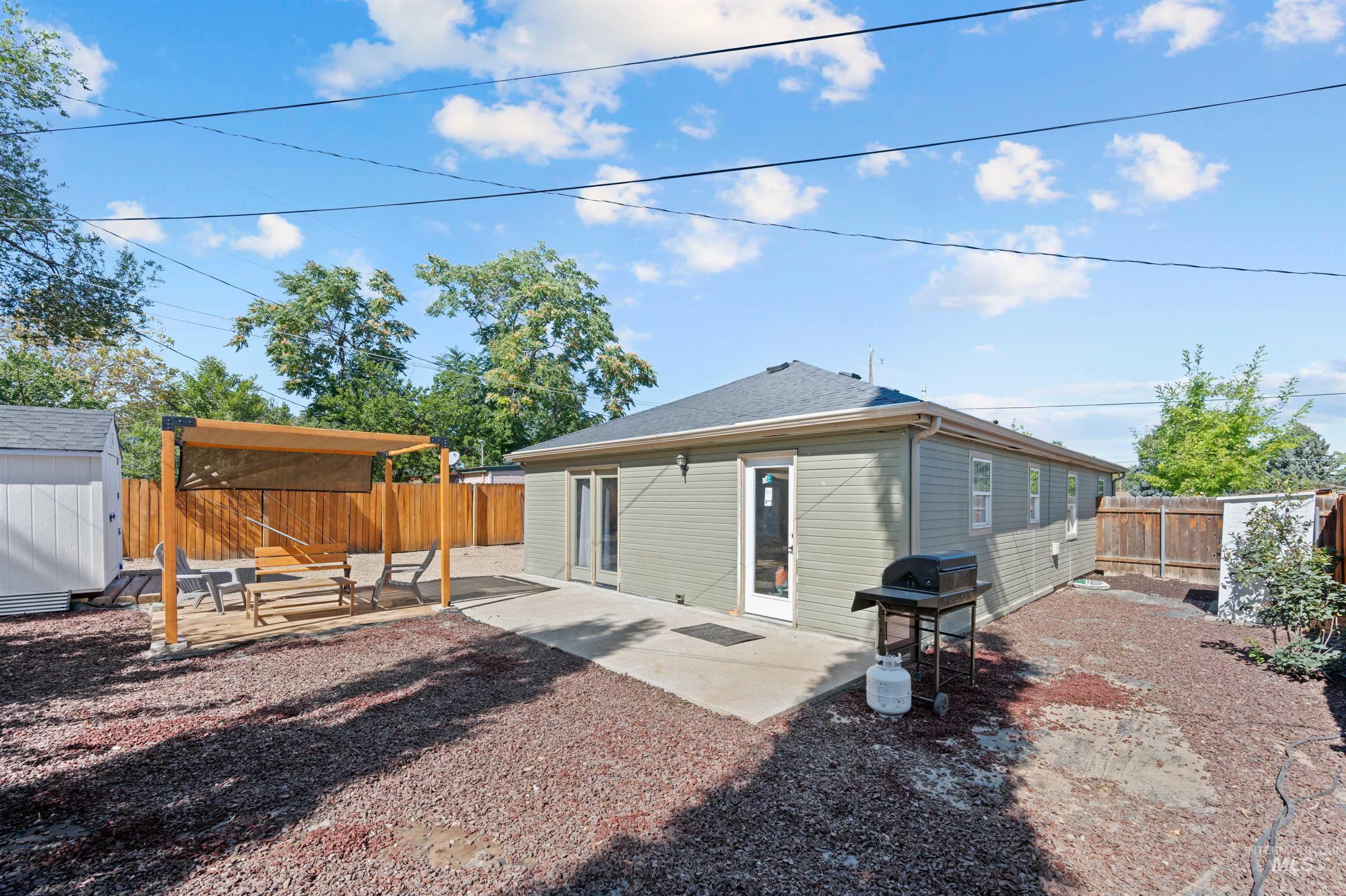 Rear view of house featuring a shed, a patio, and a fenced backyard