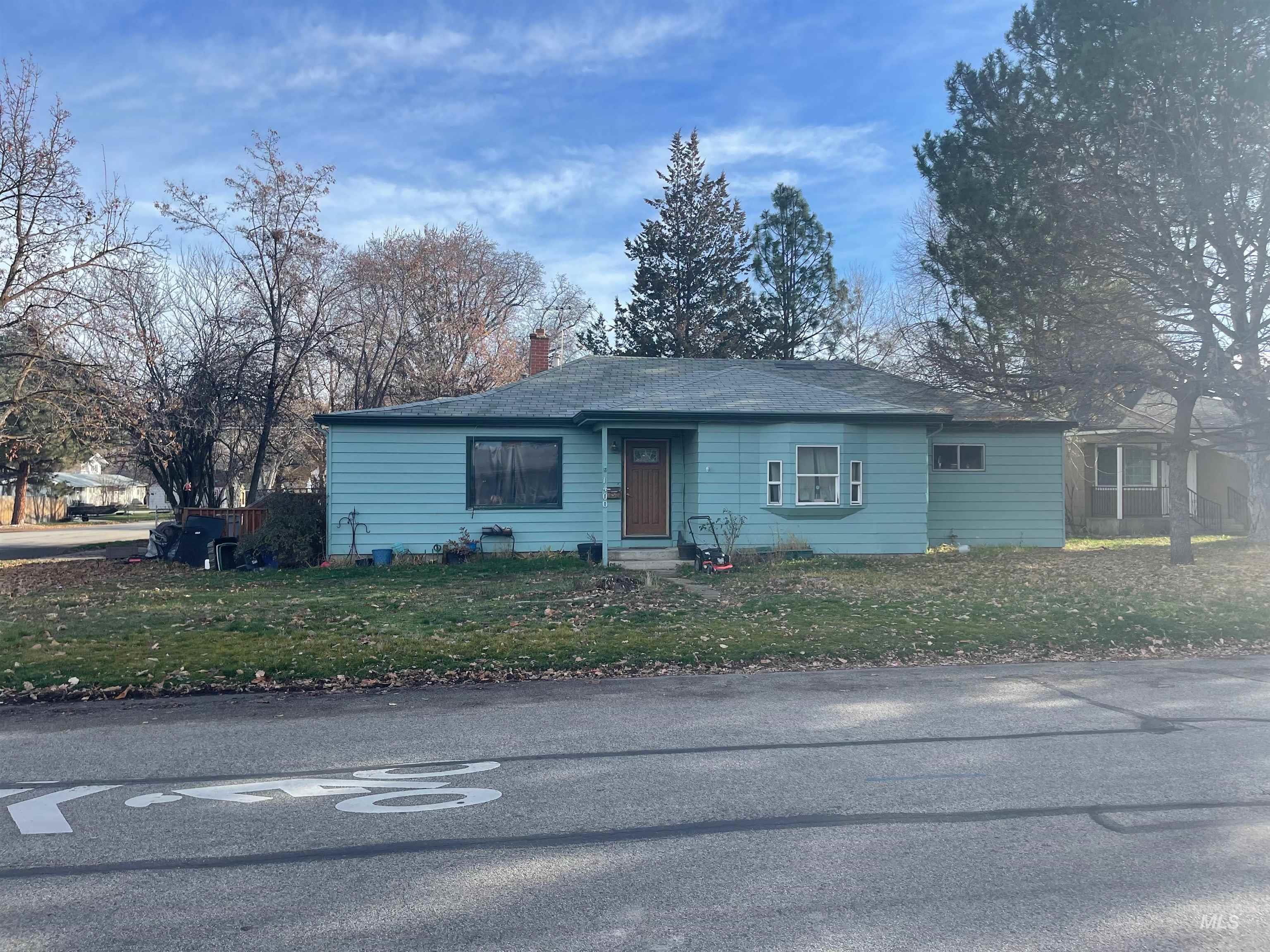Single story home featuring a chimney and a front lawn