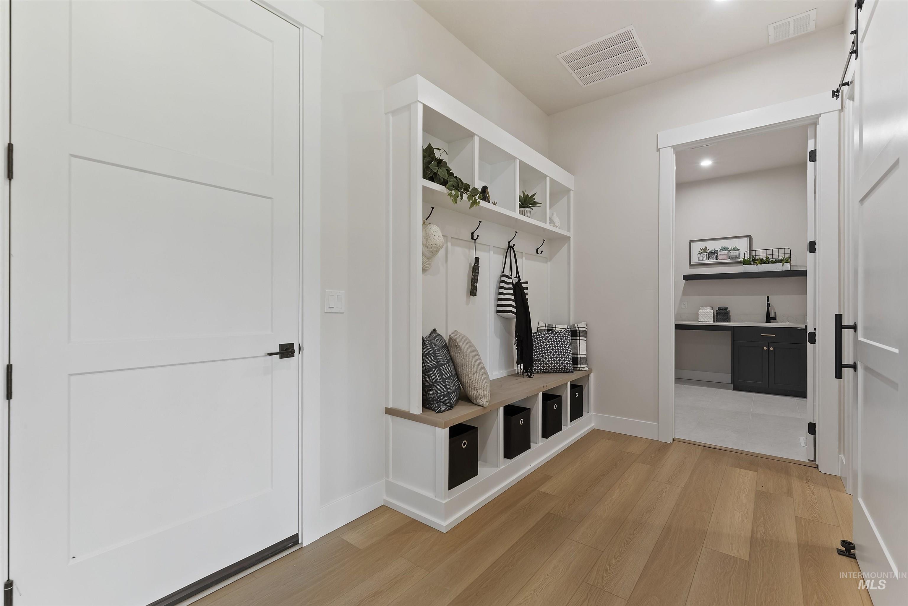 Mudroom featuring light wood-style flooring and recessed lighting
