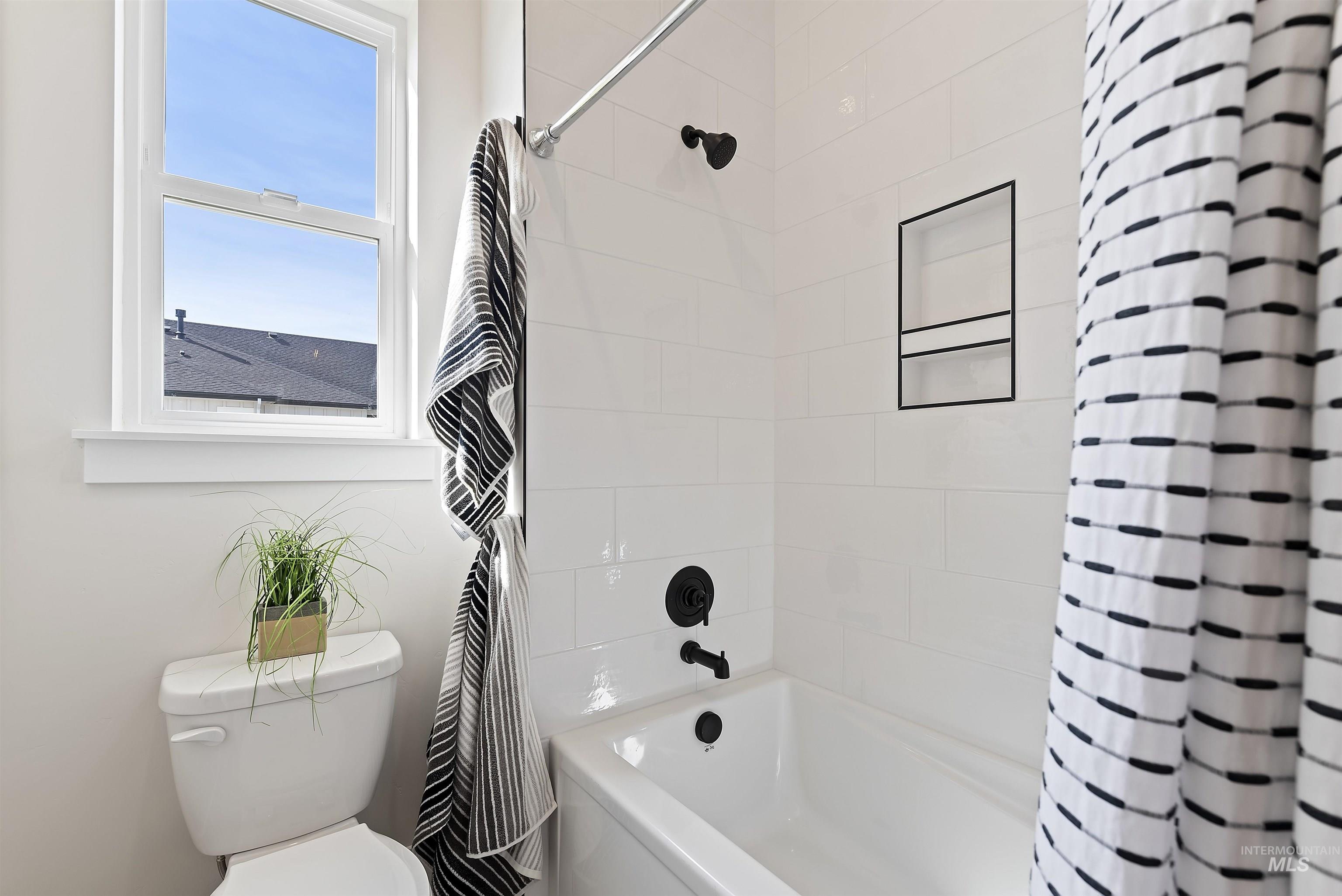 Bathroom with shower / bath combination with curtain and toilet