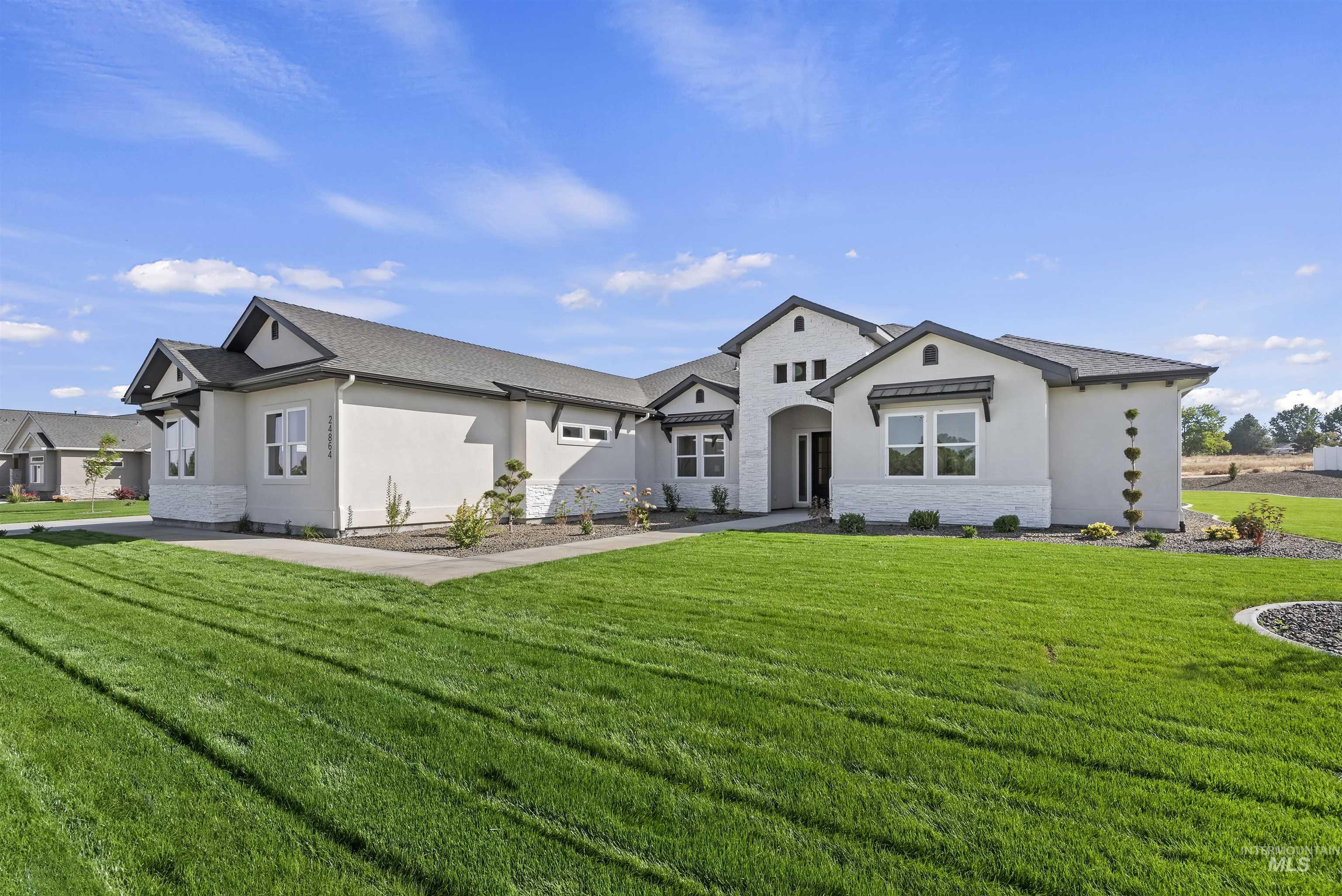 View of front of property featuring stucco siding, a front lawn, and stone siding