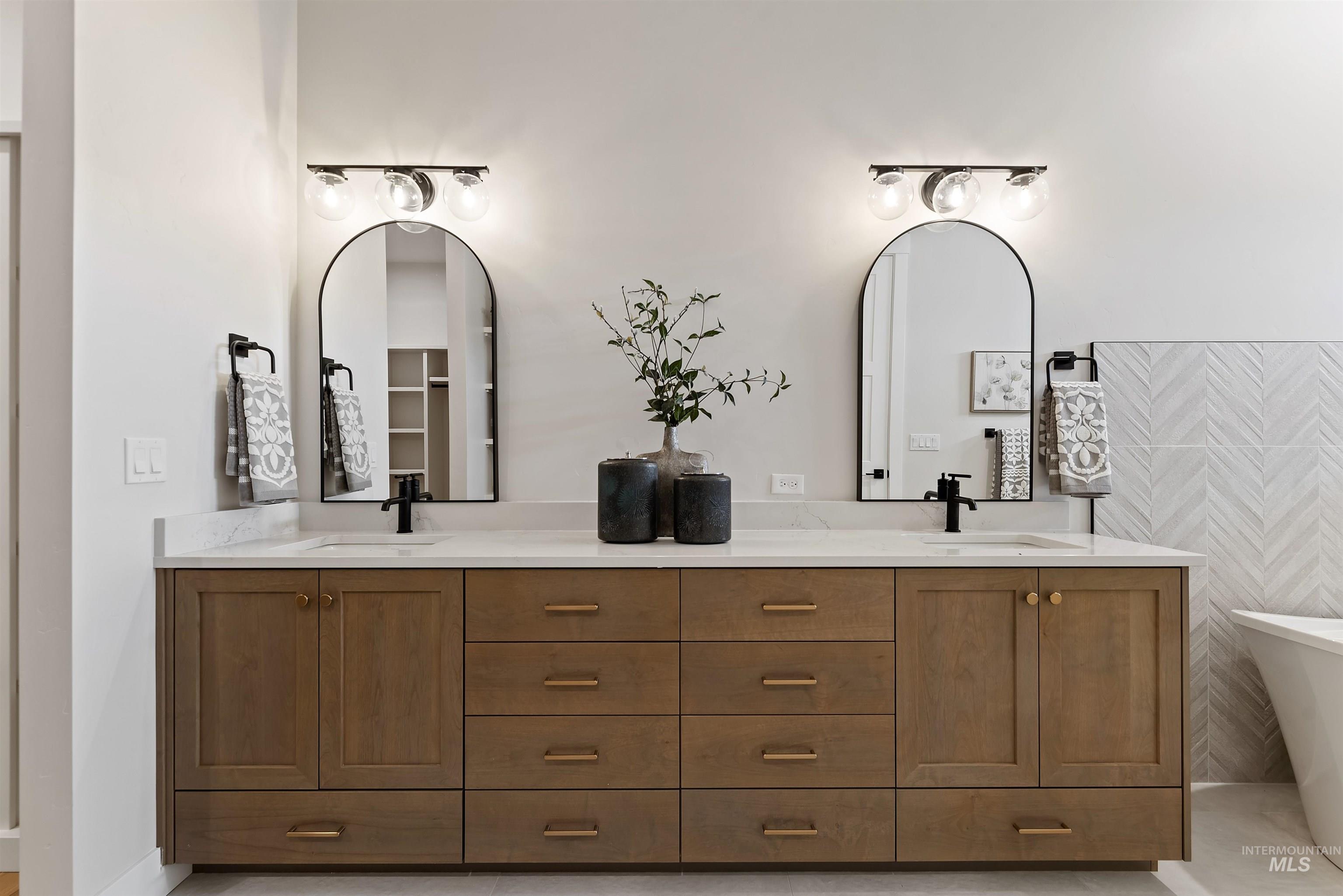 Bathroom with double vanity, a freestanding tub, and light tile patterned flooring