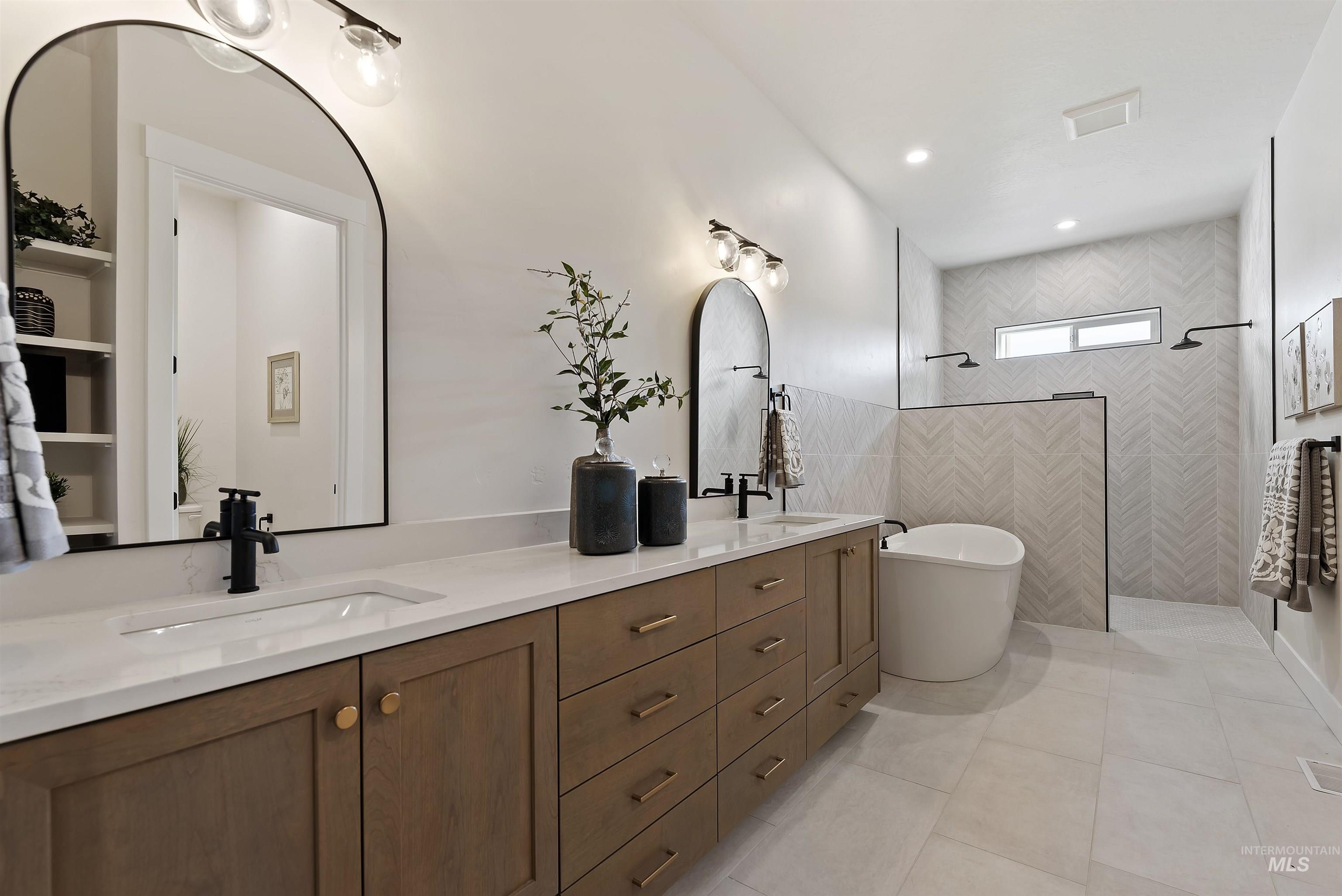 Bathroom with a walk in shower, double vanity, light tile patterned floors, recessed lighting, and a freestanding tub