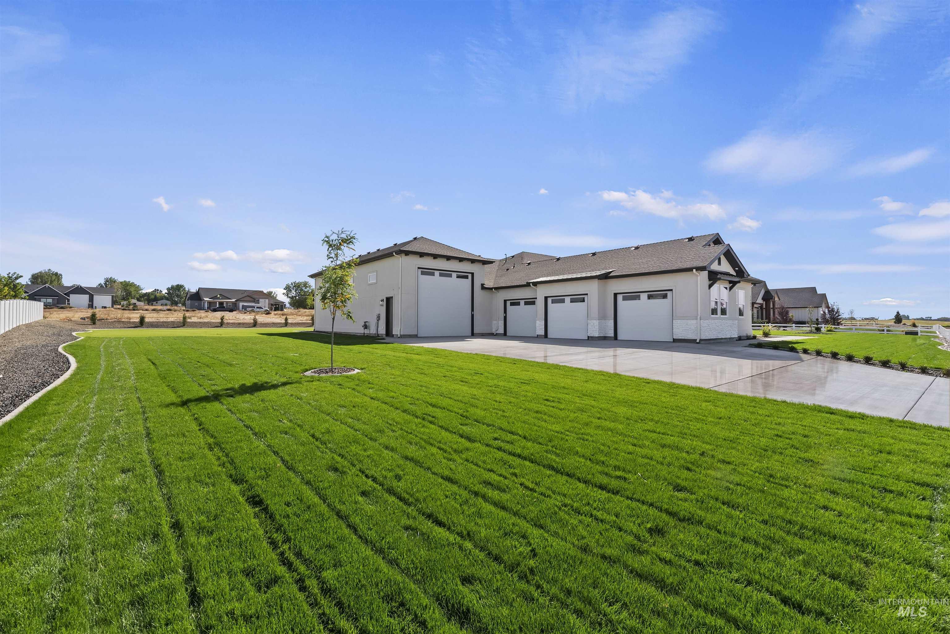 View of front facade with concrete driveway, a garage, and stucco siding