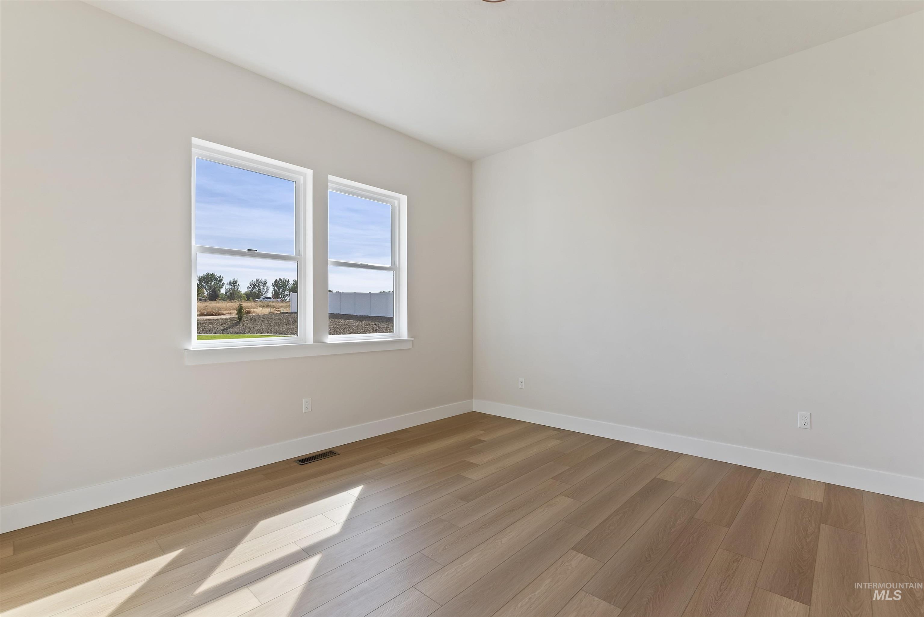 Empty room with baseboards and light wood finished floors
