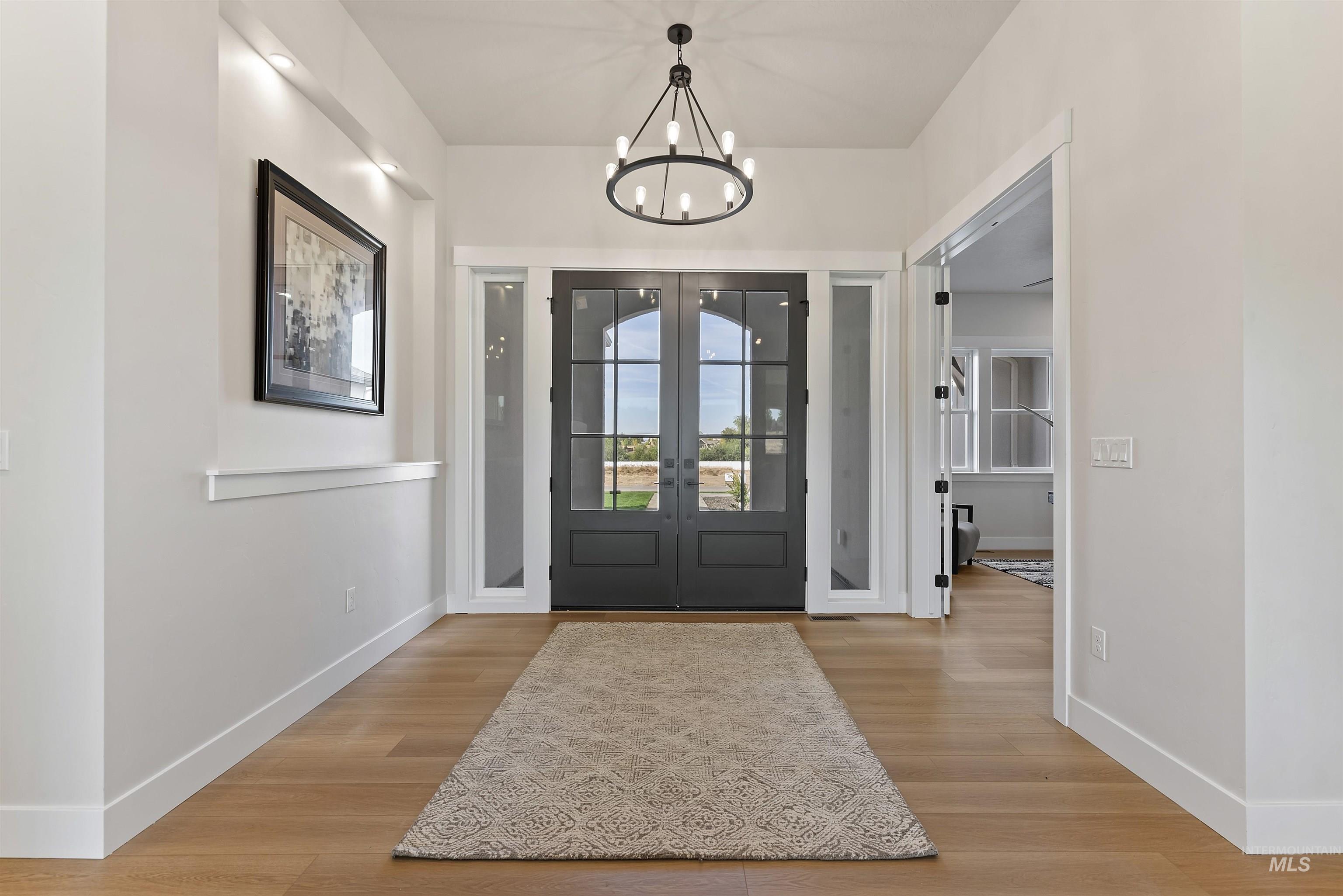 Foyer entrance featuring light wood-type flooring and a chandelier