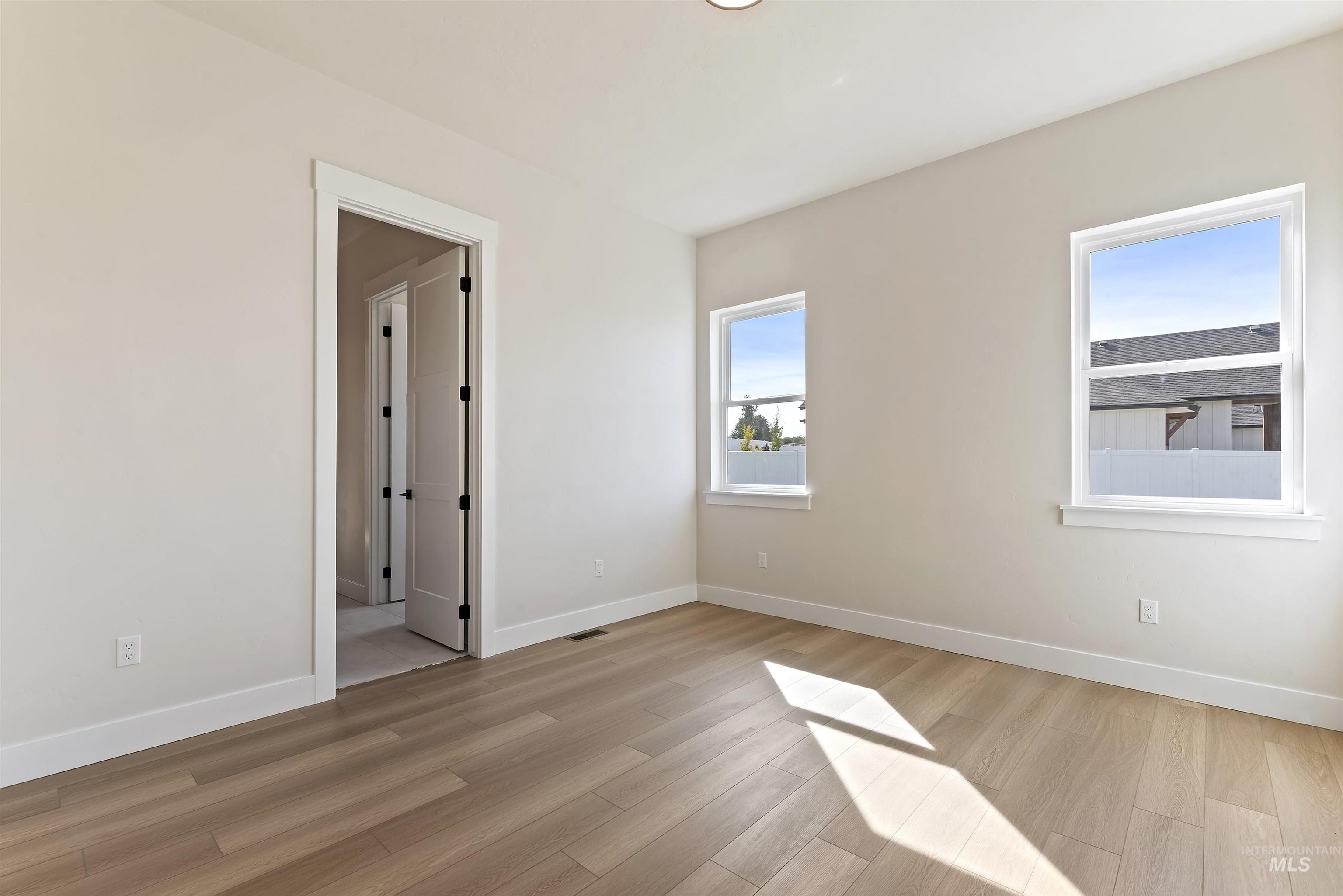 Spare room with baseboards and light wood-style flooring