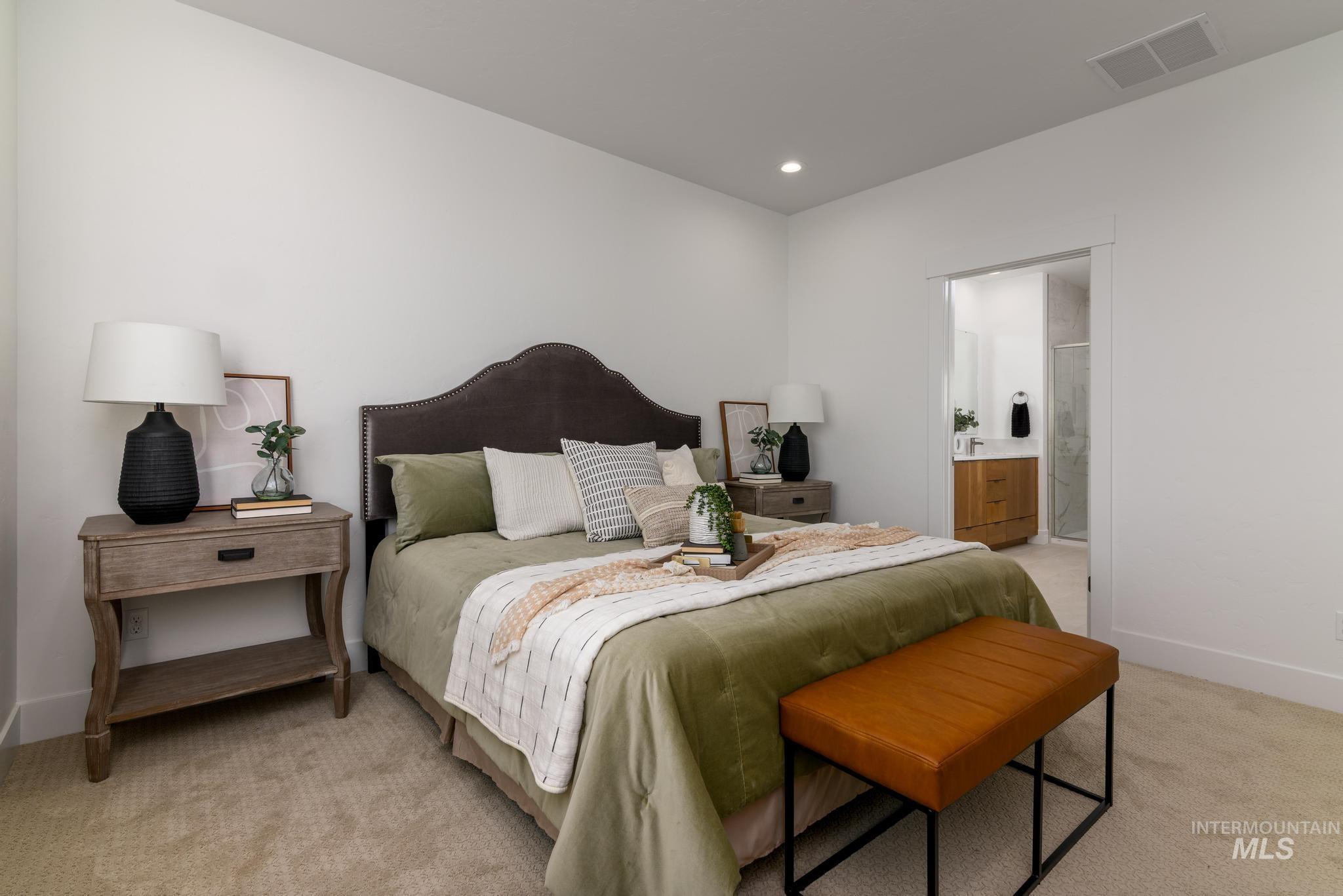 Bedroom with light colored carpet, connected bathroom, and recessed lighting