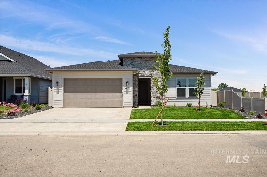 Prairie-style house with concrete driveway, a garage, and stone siding