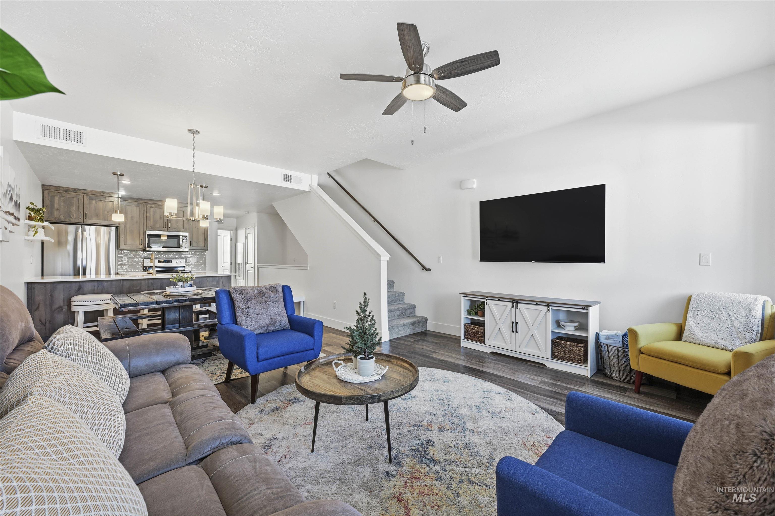 Living area featuring hanging lights, wood finished floors, and a ceiling fan