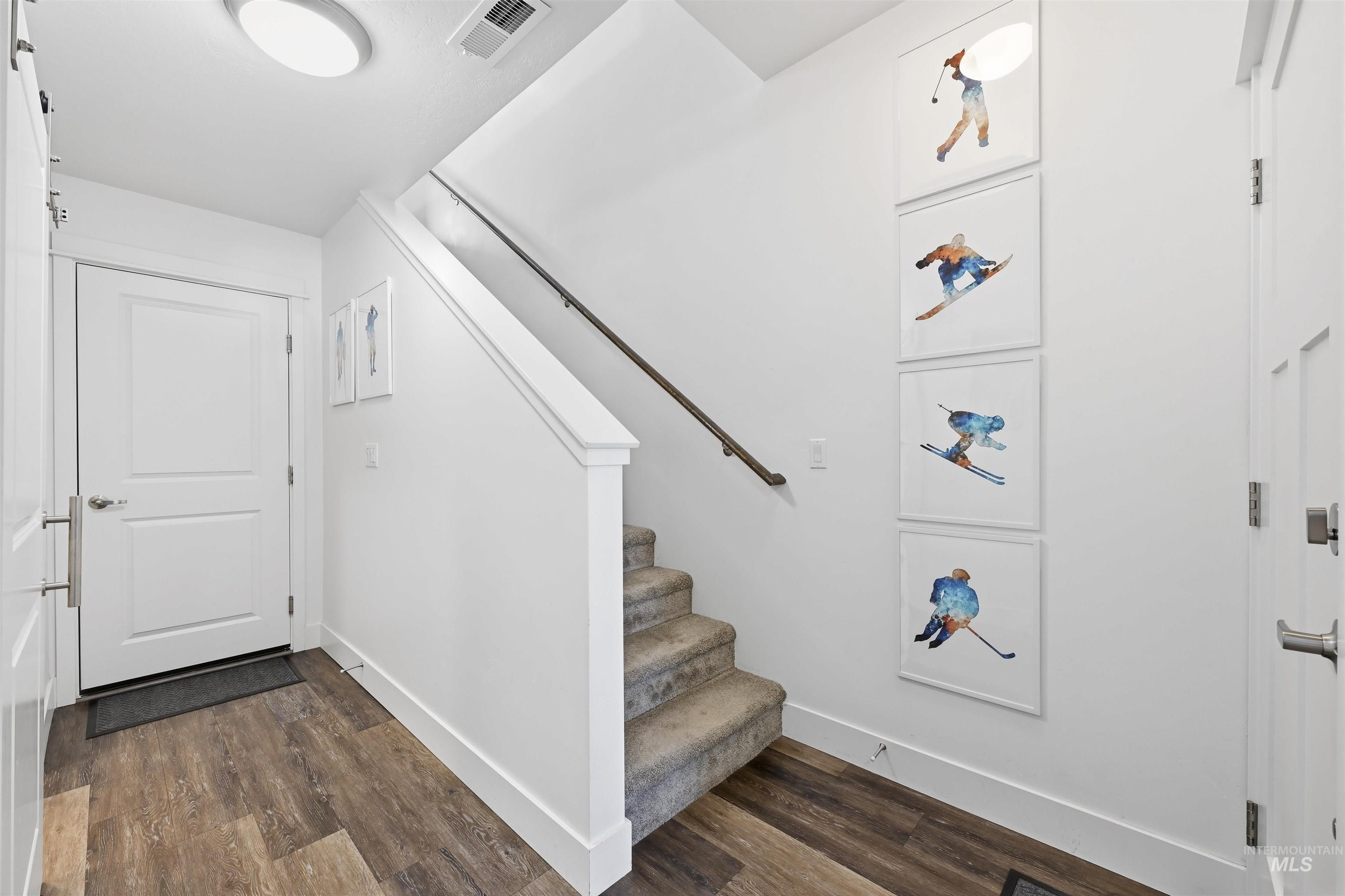 Foyer entrance featuring stairway and dark wood-style floors