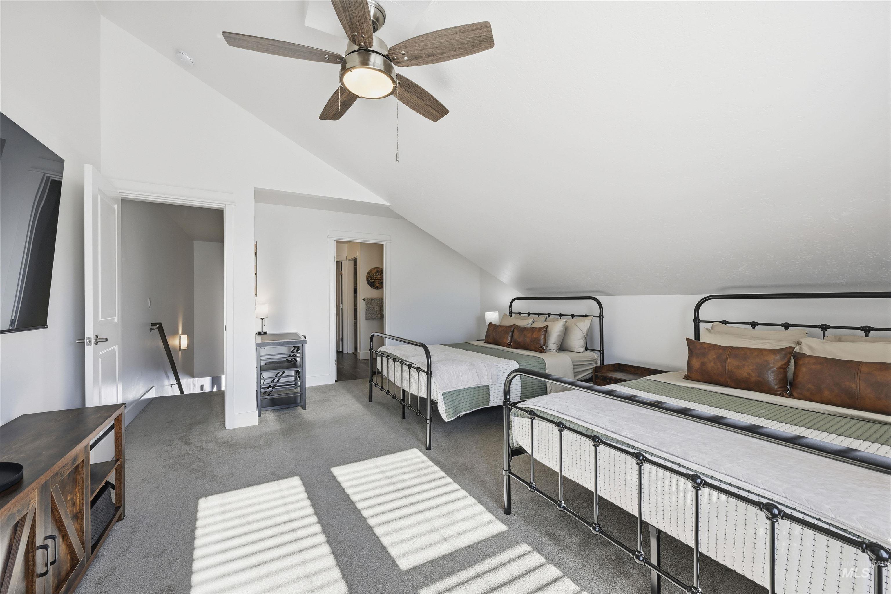 Bedroom featuring lofted ceiling, carpet, a ceiling fan, and ensuite bath