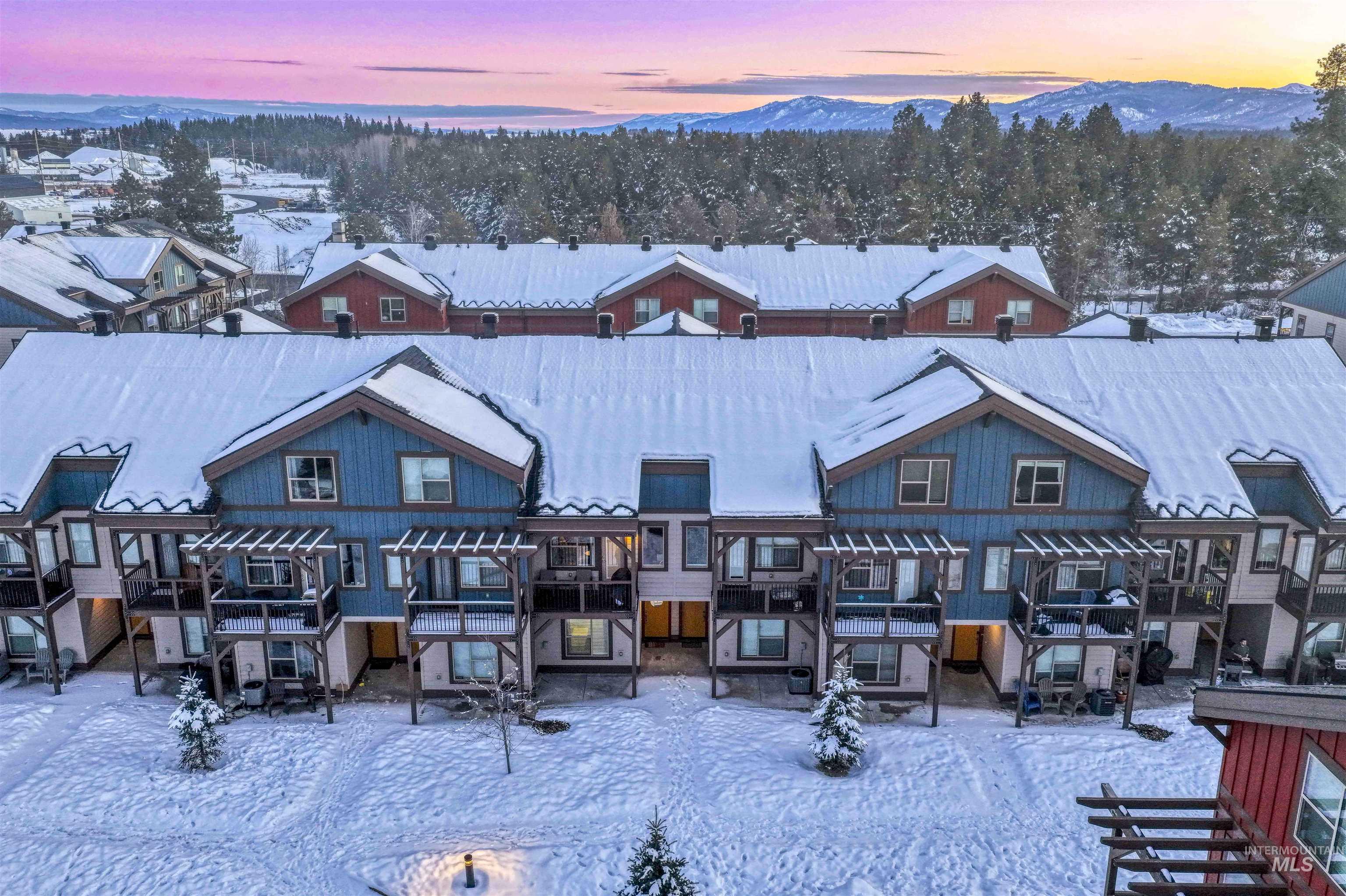 Snow covered front of property with a patio, a residential view, and a pergola