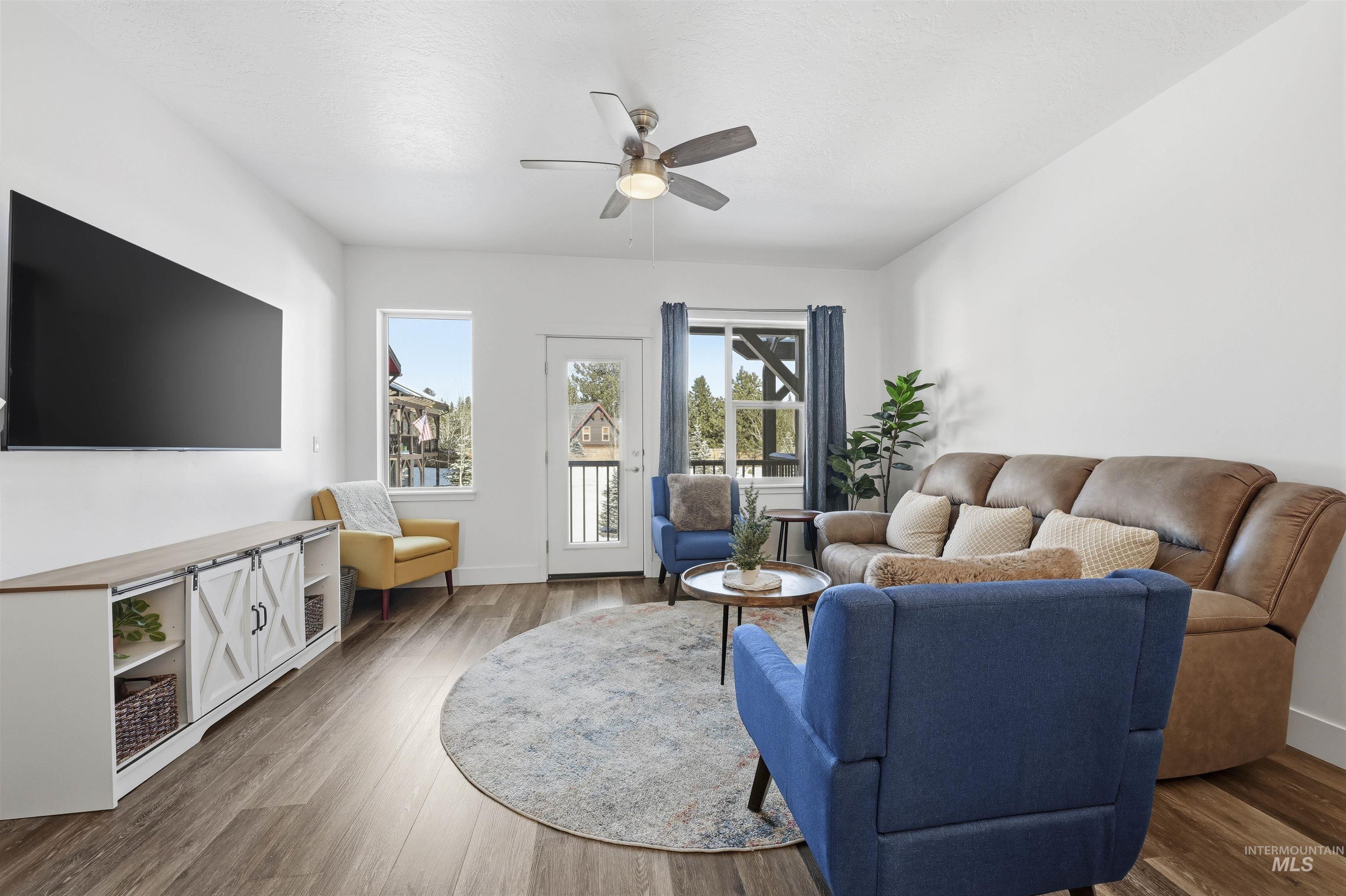 Living room with wood finished floors and a ceiling fan
