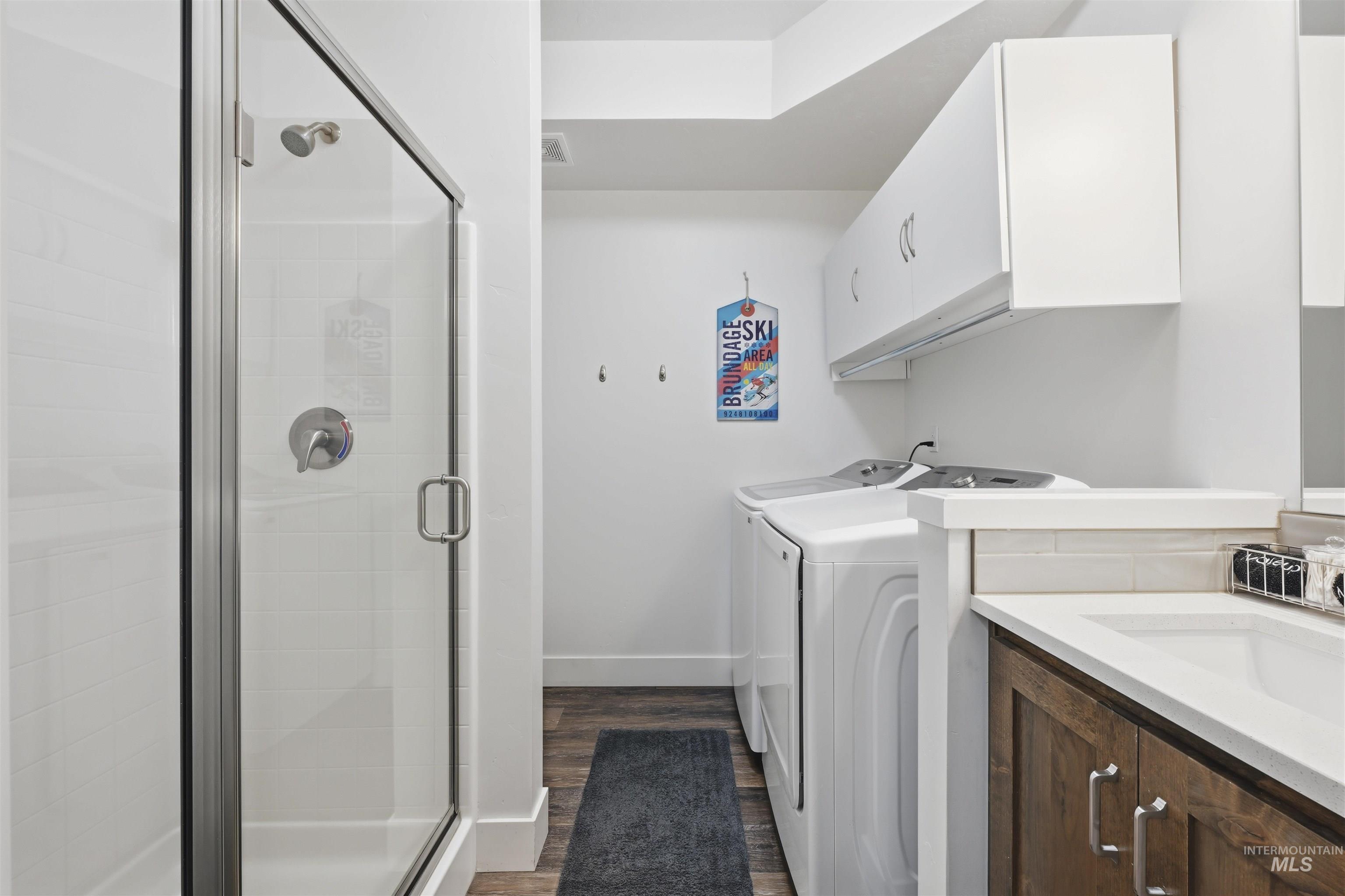 Laundry area featuring dark wood finished floors and washing machine and clothes dryer