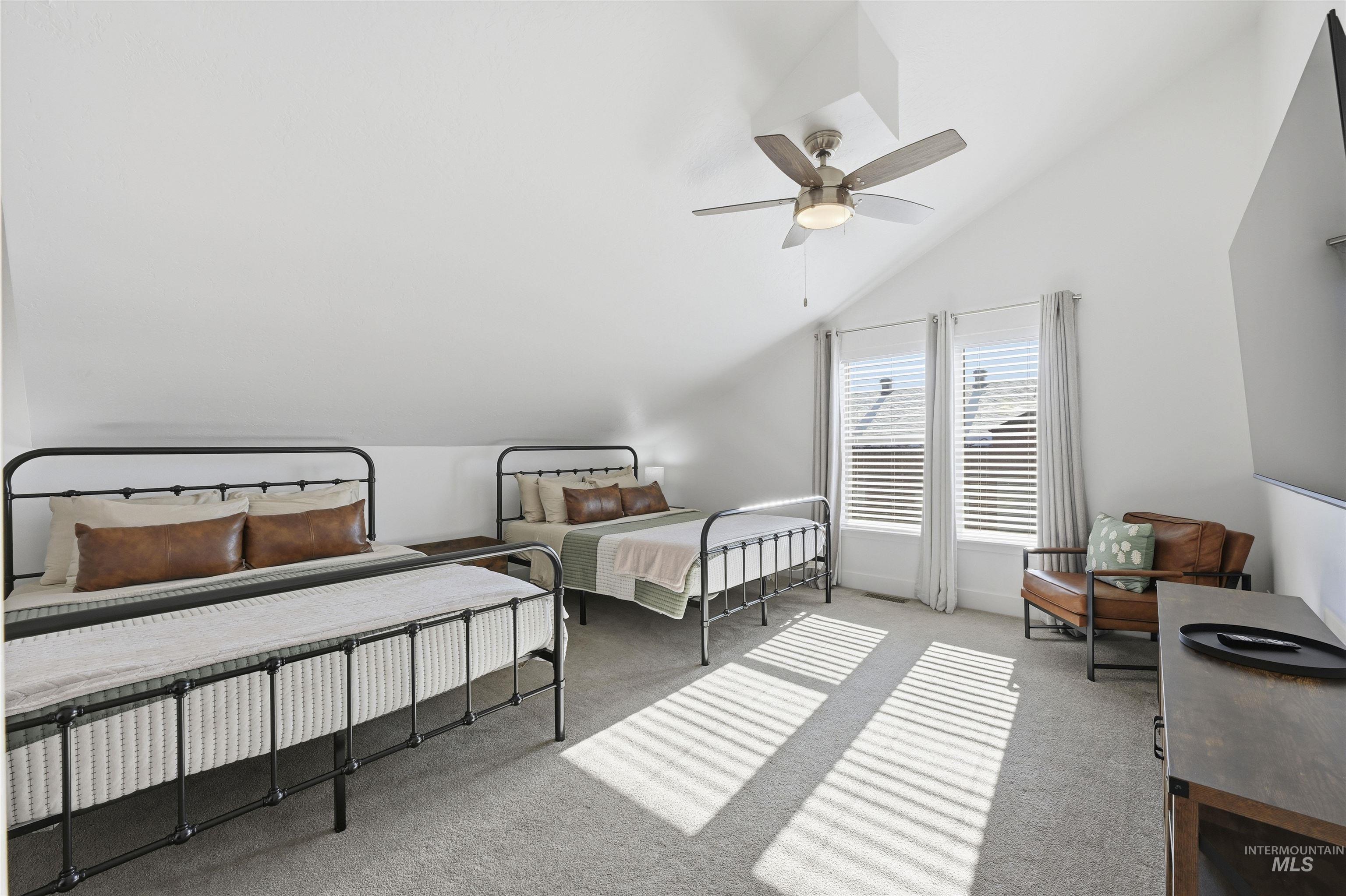 Bedroom featuring light carpet, lofted ceiling, and ceiling fan