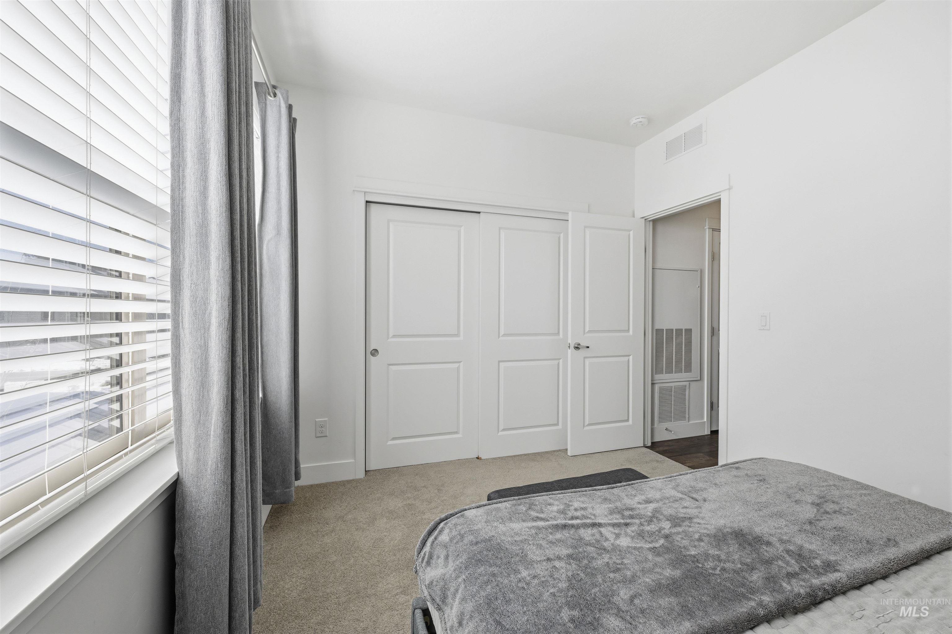 Bedroom featuring light carpet and a closet