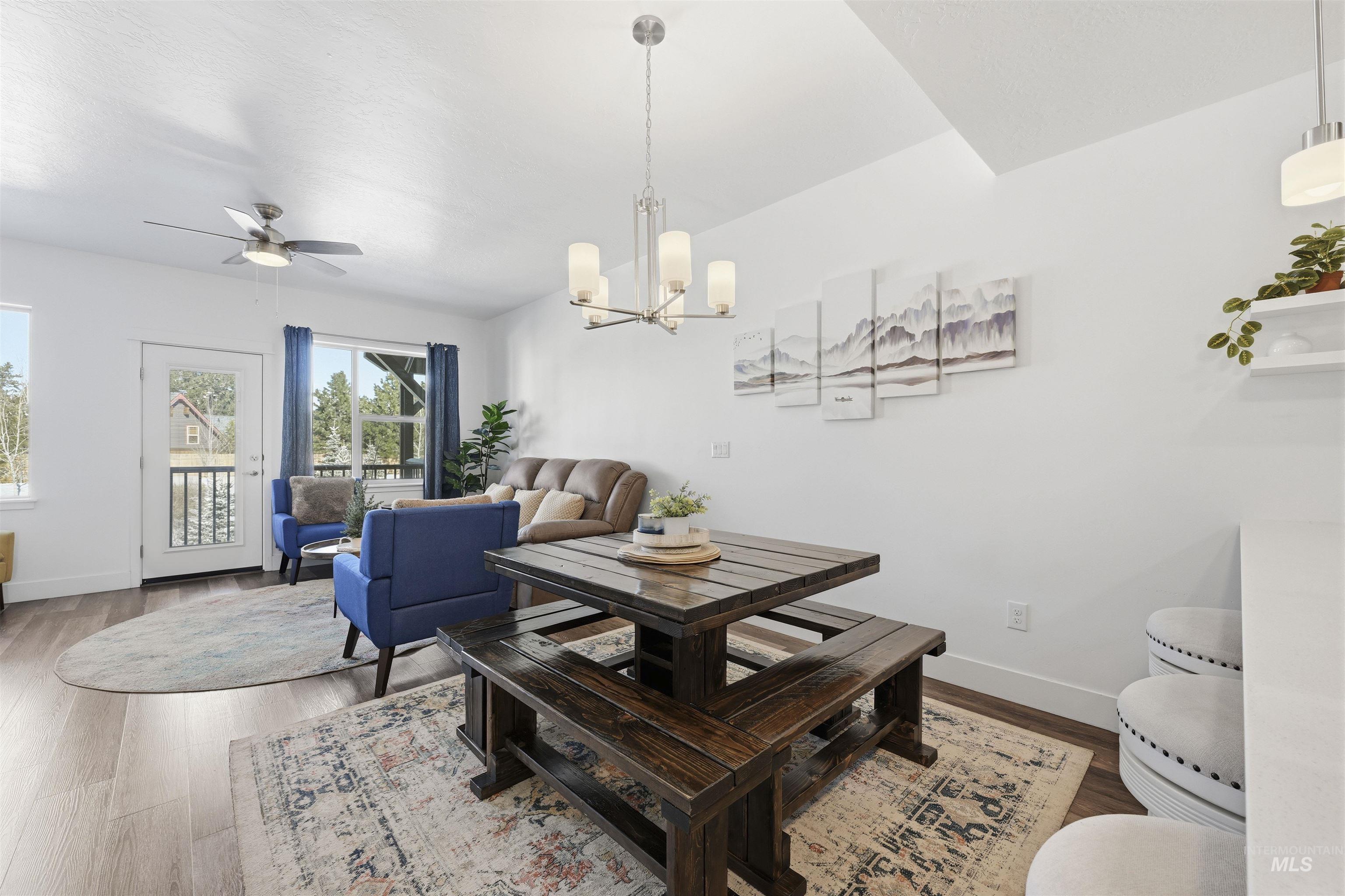 Dining area featuring ceiling fan, wood finished floors, and hanging lights