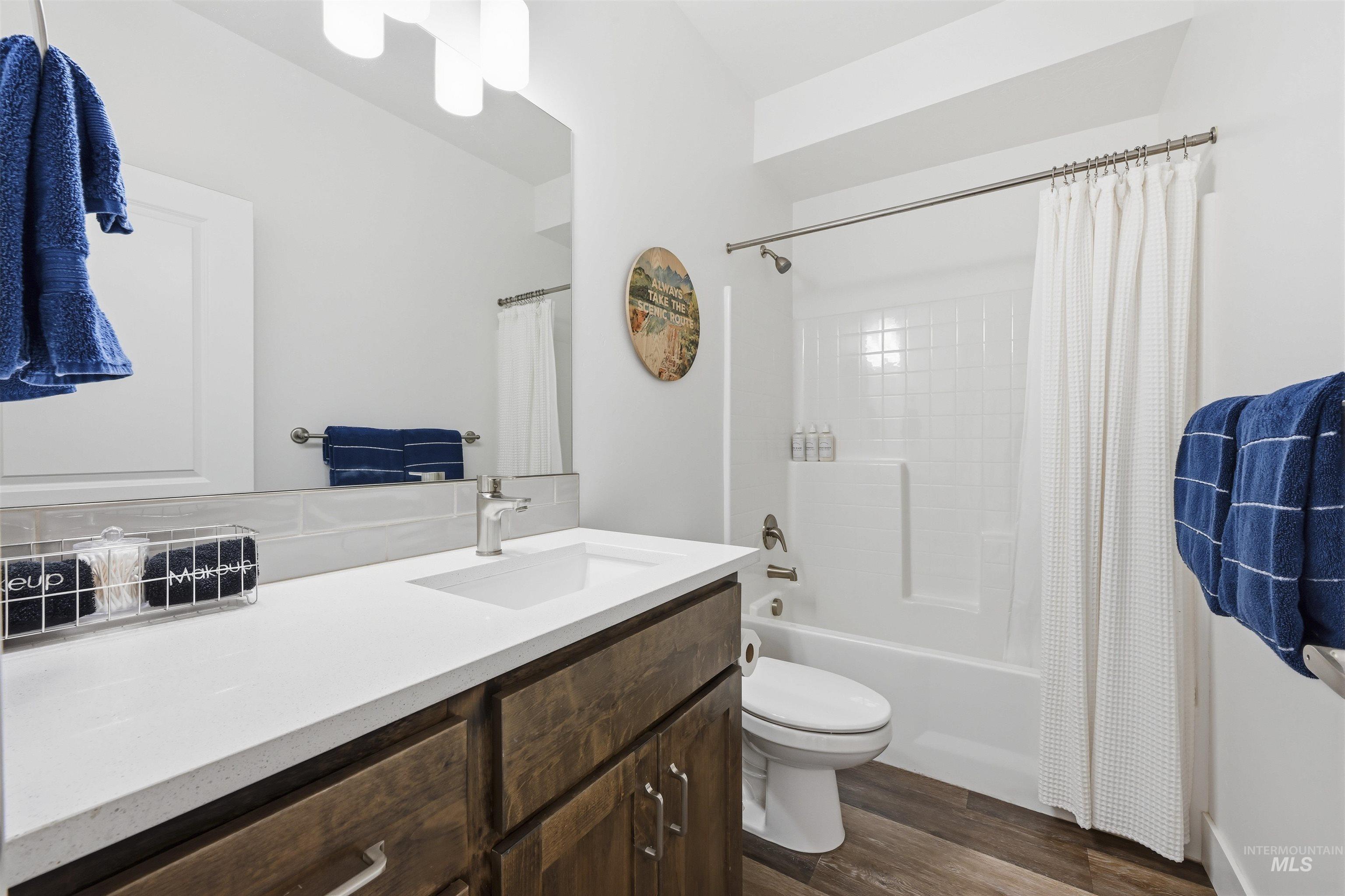 Bathroom featuring vanity, dark wood-type flooring, and shower / tub combo