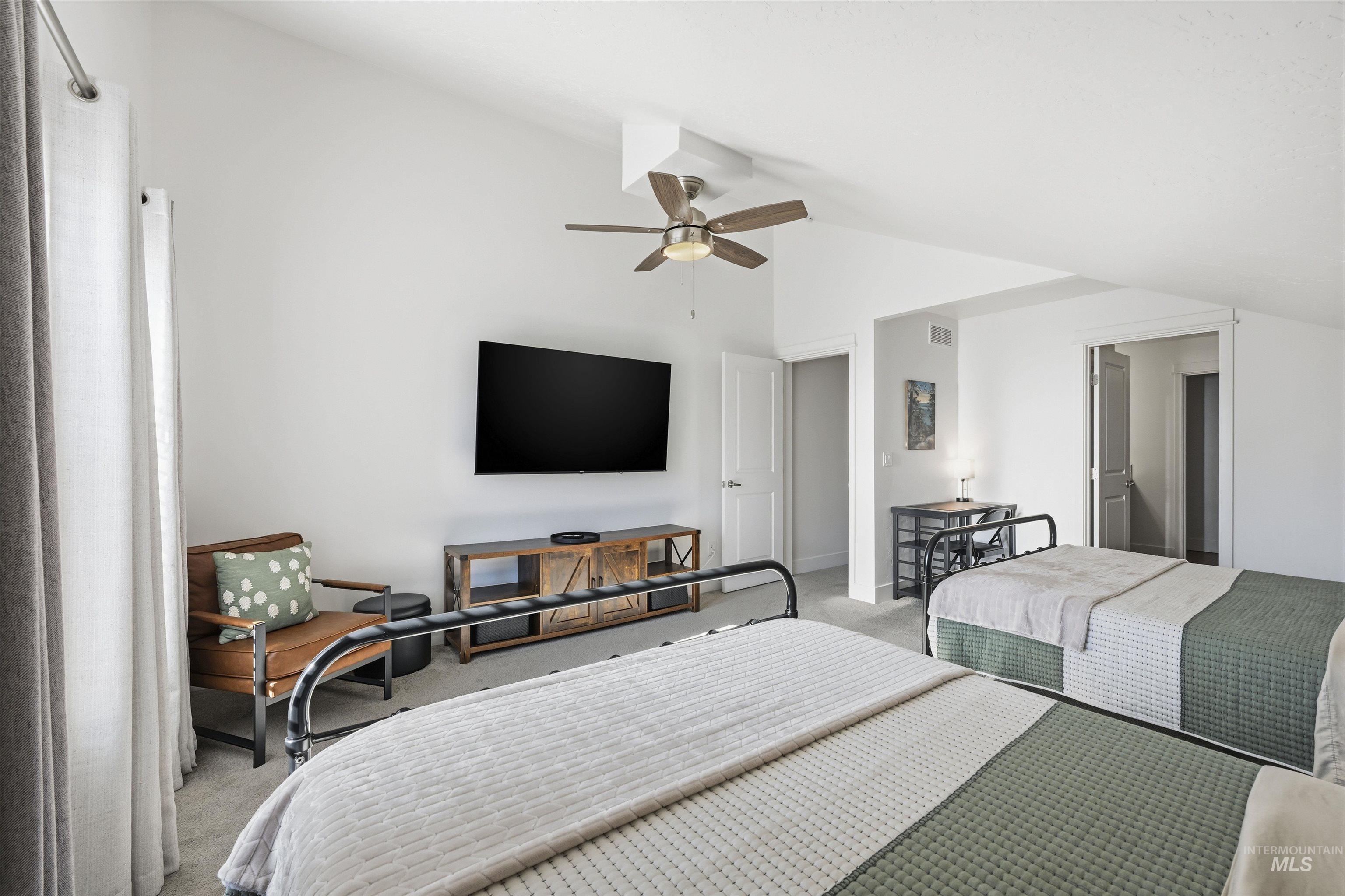 Bedroom with carpet floors, lofted ceiling, and a ceiling fan