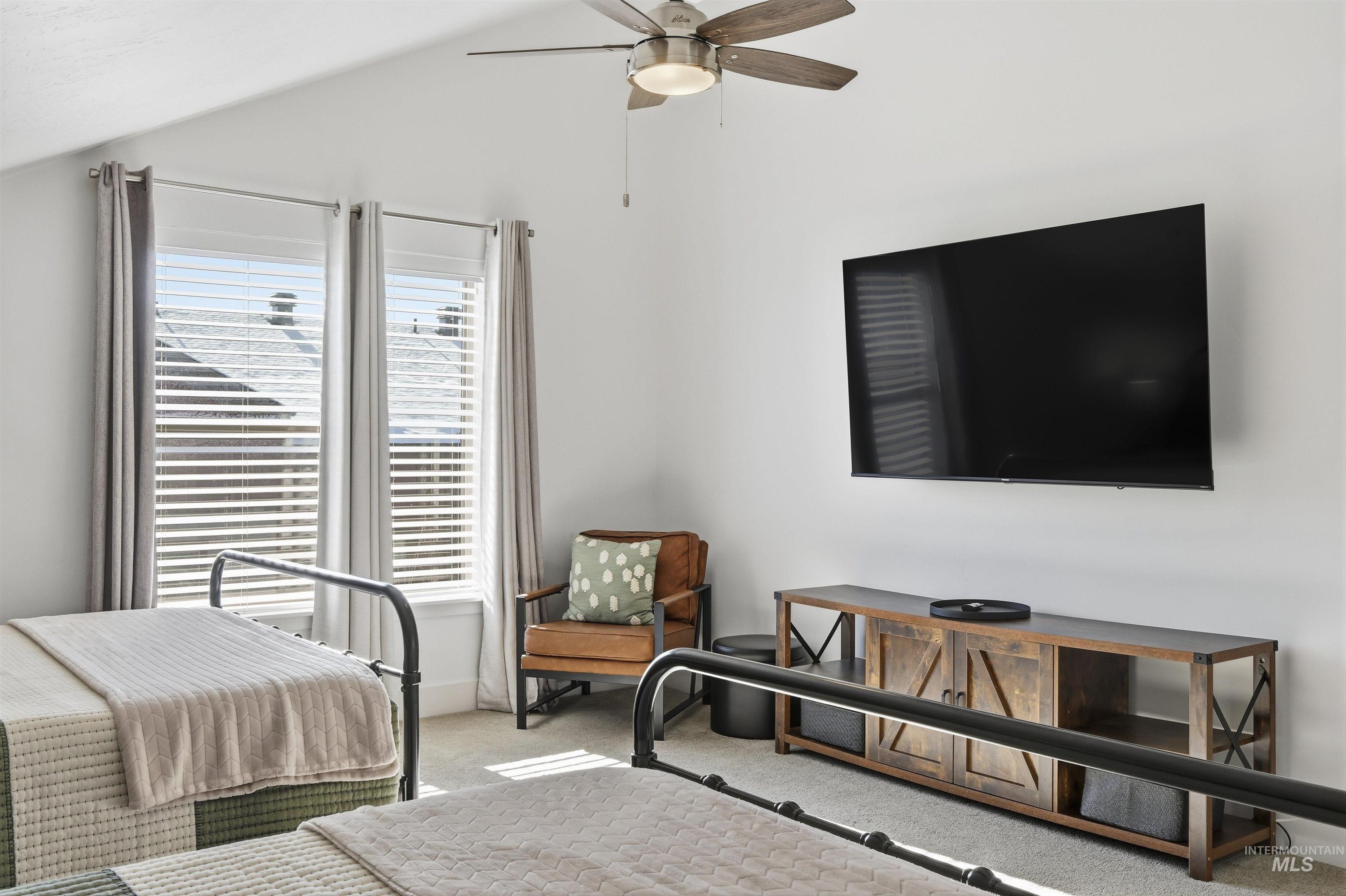 Bedroom featuring carpet floors, a ceiling fan, and lofted ceiling