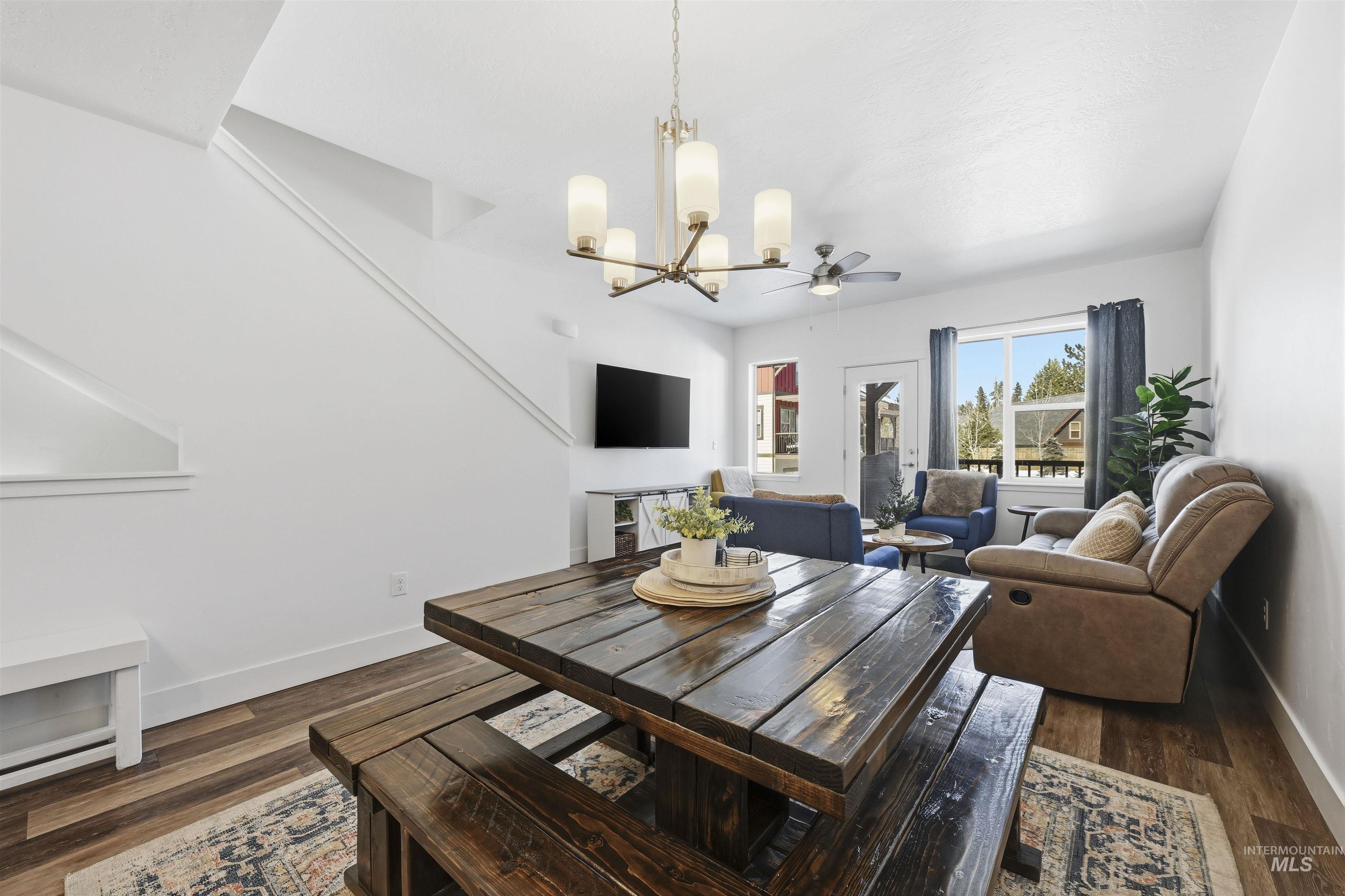 Dining room with hanging lights, dark wood finished floors, and a ceiling fan