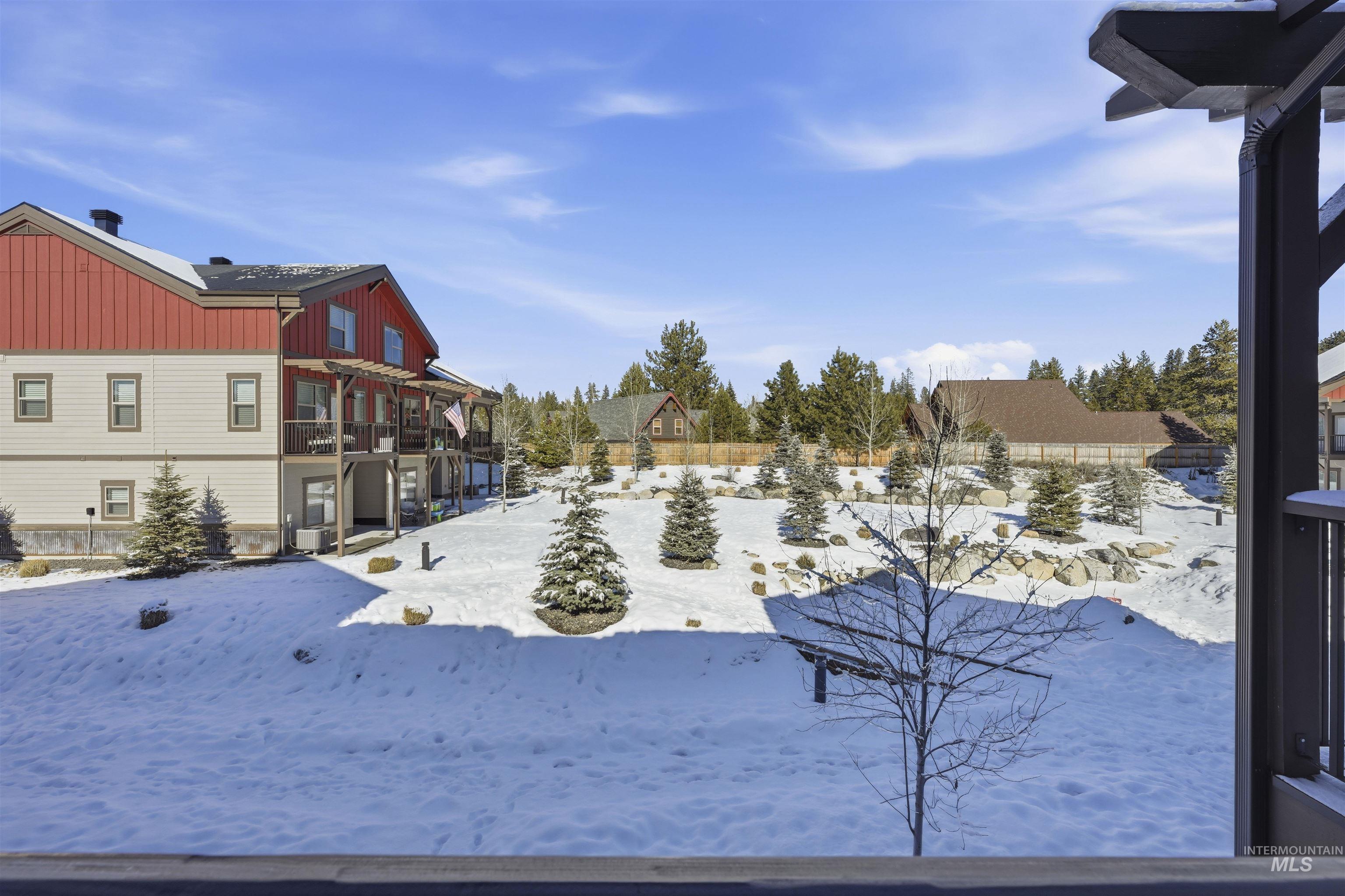 Yard covered in snow featuring a balcony and a residential view
