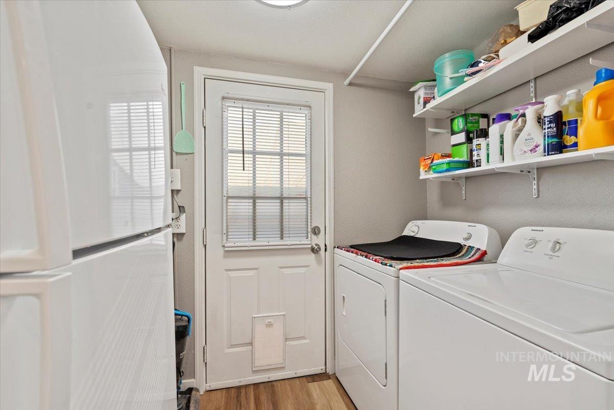 Laundry area featuring light wood-style flooring and washing machine and dryer