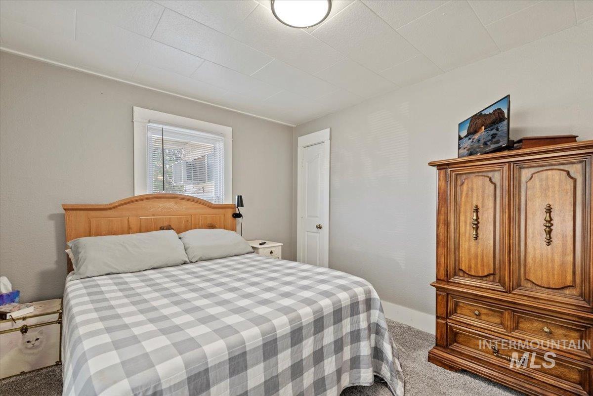 Bedroom with light colored carpet and baseboards