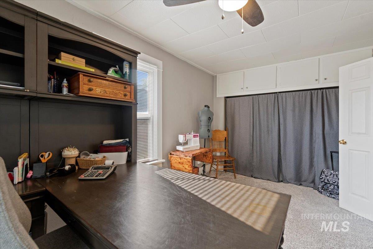 Home office featuring carpet and a ceiling fan