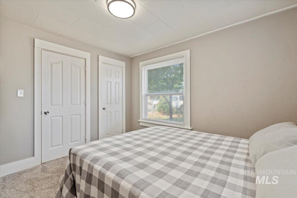 Carpeted bedroom with a textured wall and baseboards
