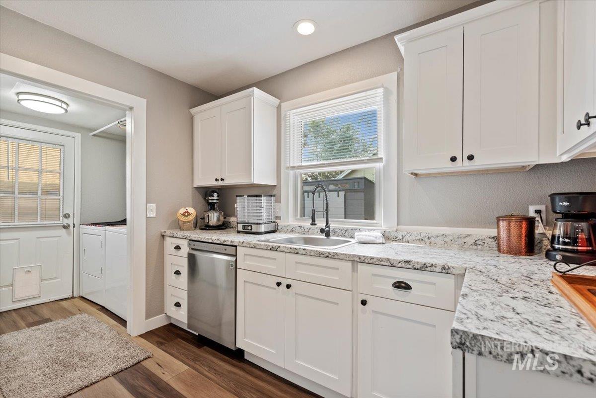 Kitchen with white cabinets, dark wood finished floors, dishwasher, washing machine and dryer, and recessed lighting